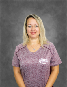 A woman wearing a purple shirt with the word reebok on it