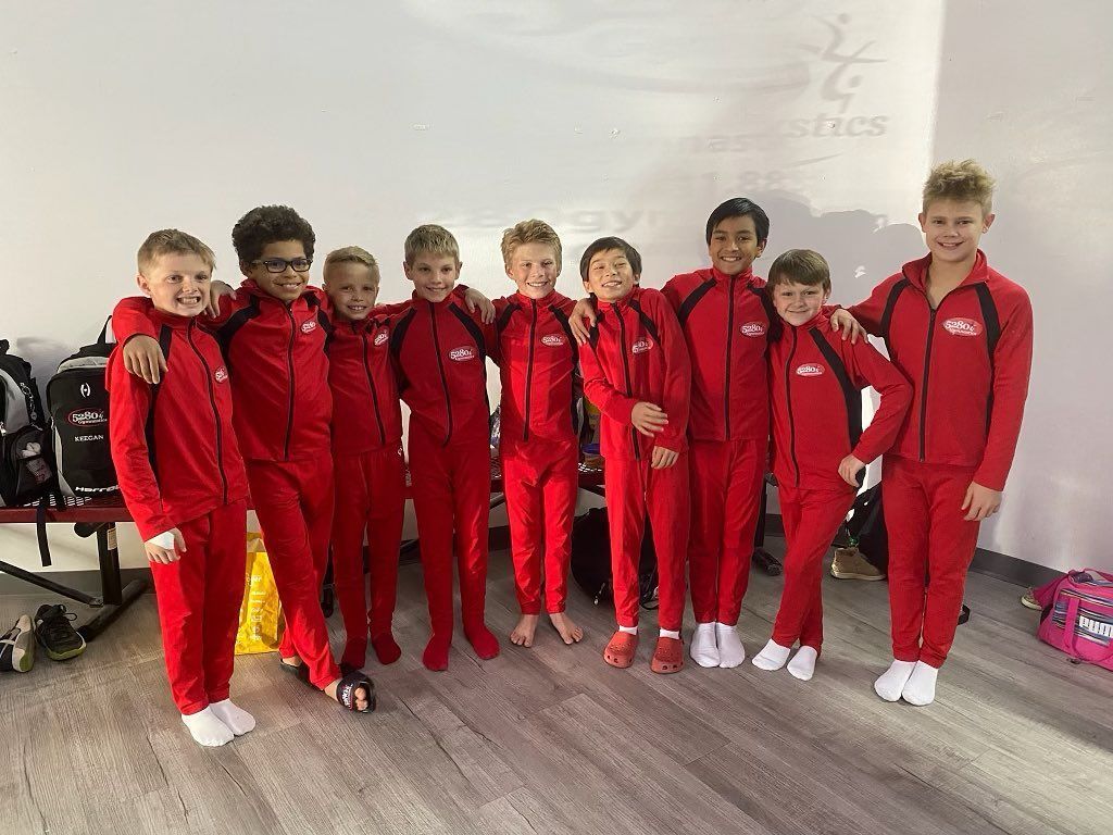 A group of young boys in red jumpsuits are posing for a picture.