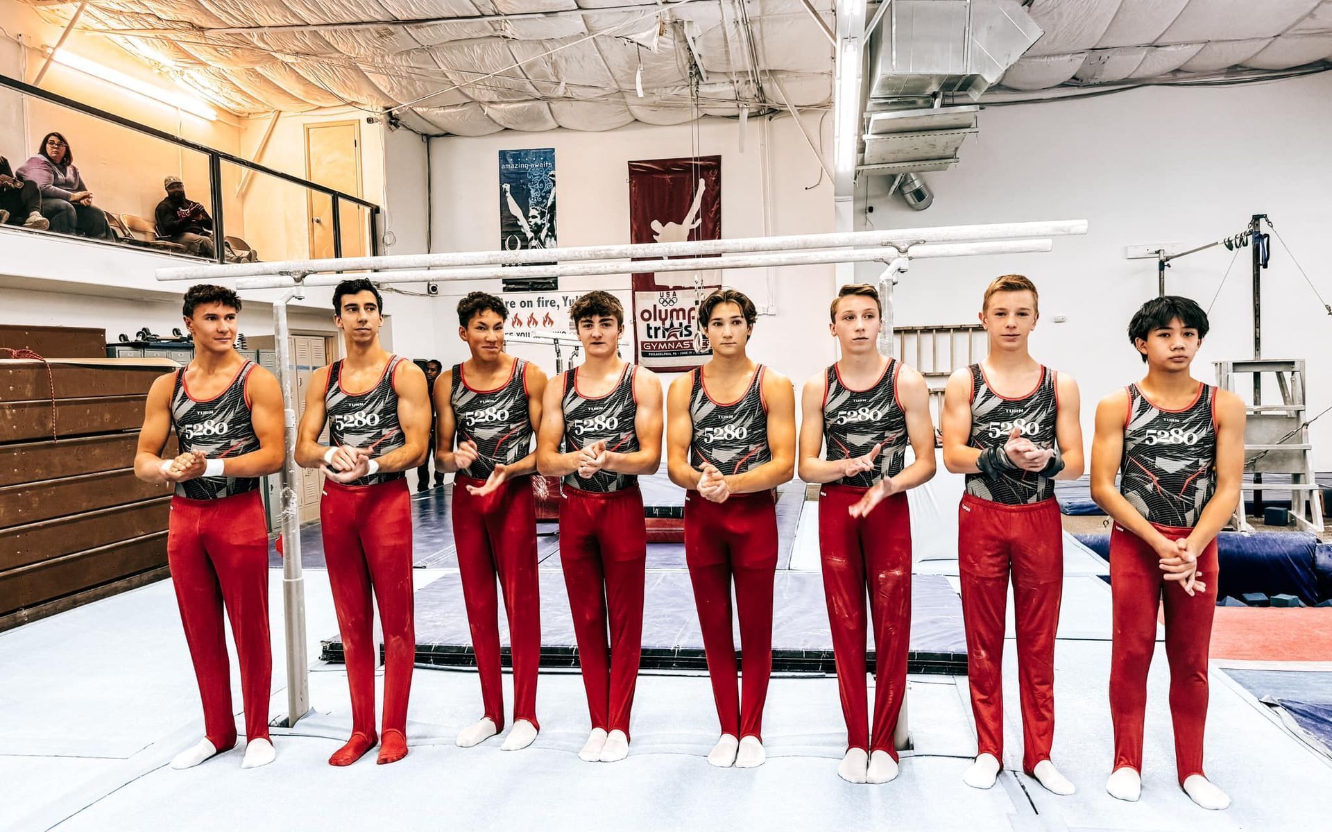 A group of young men are standing next to each other in a gym.