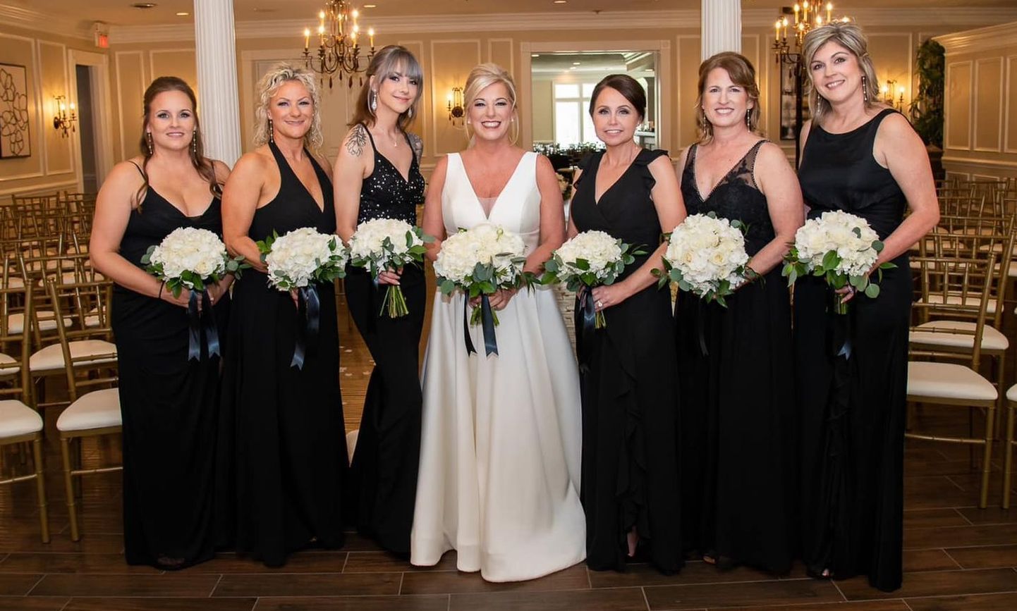 a bride and her bridesmaids are posing for a picture in a room with chairs .