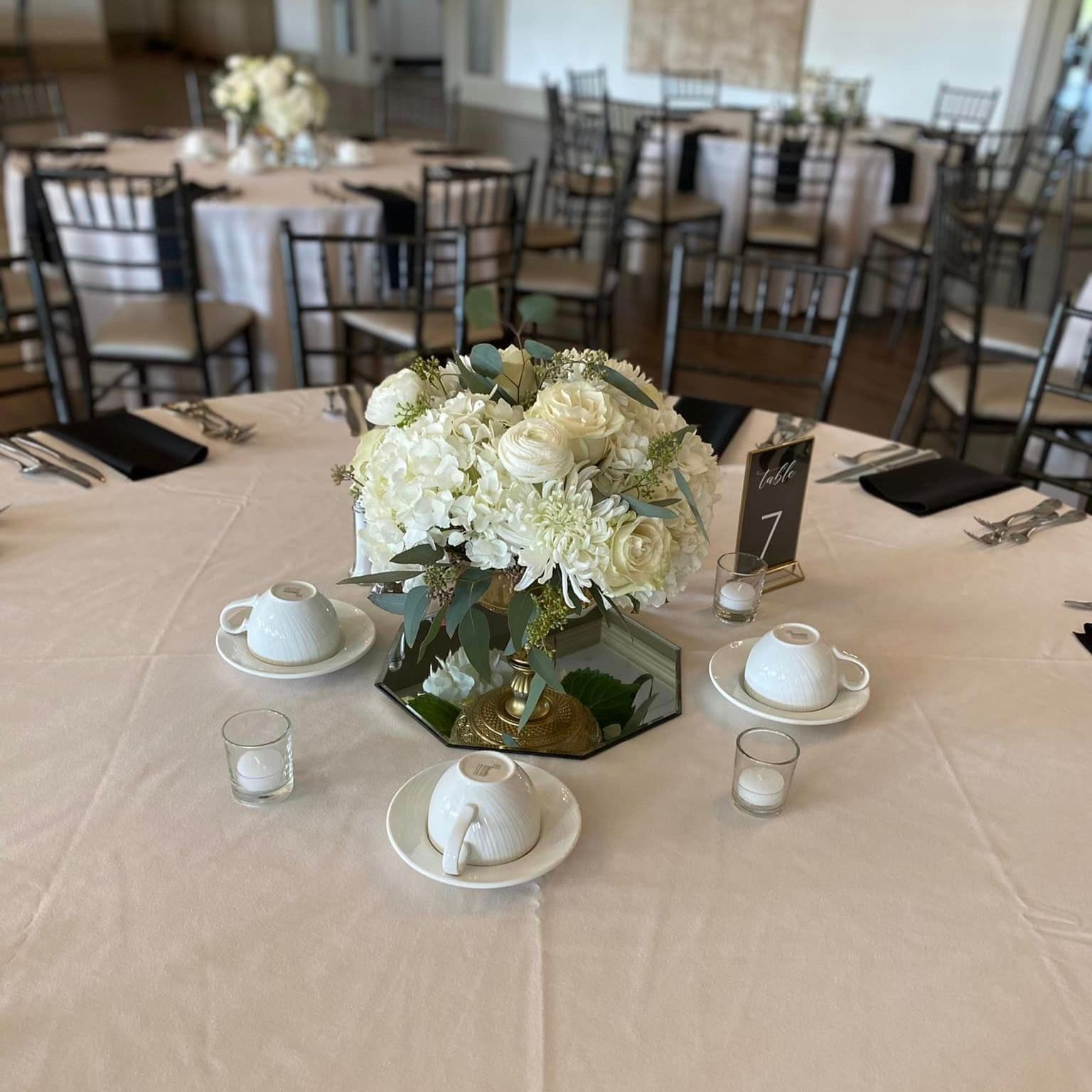 a table set for a wedding reception with a vase of flowers on it .