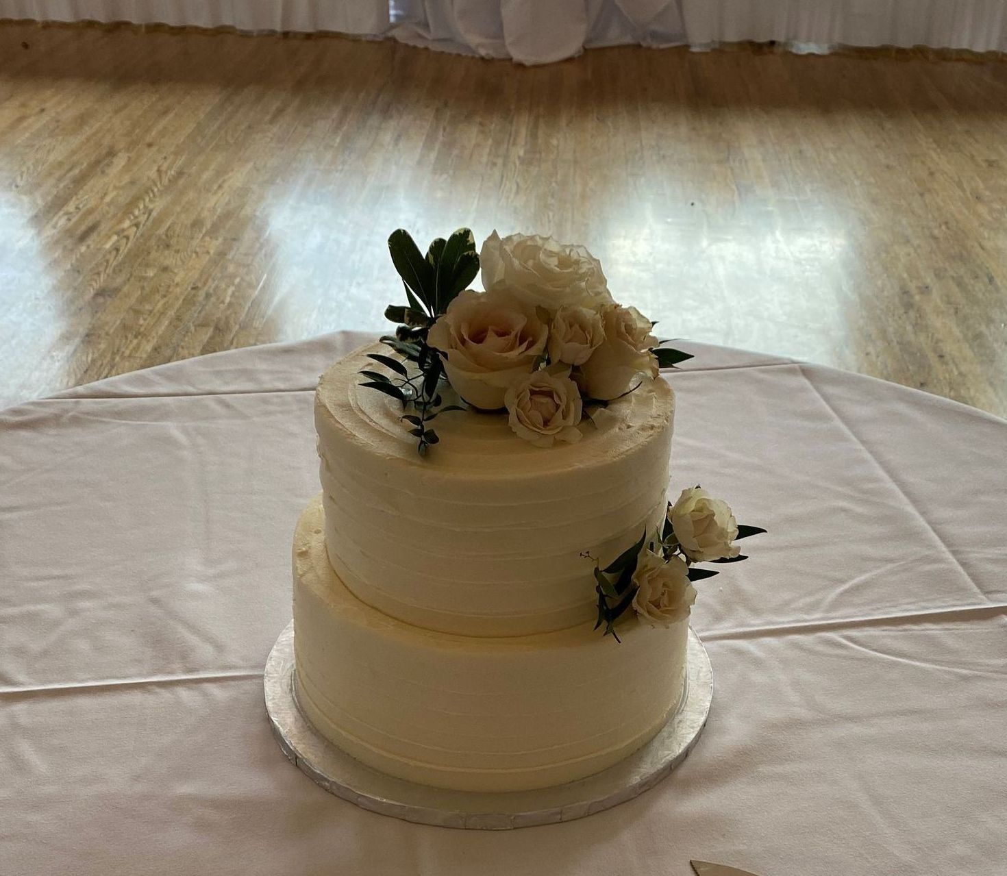 a white cake with flowers on top of it is on a table .