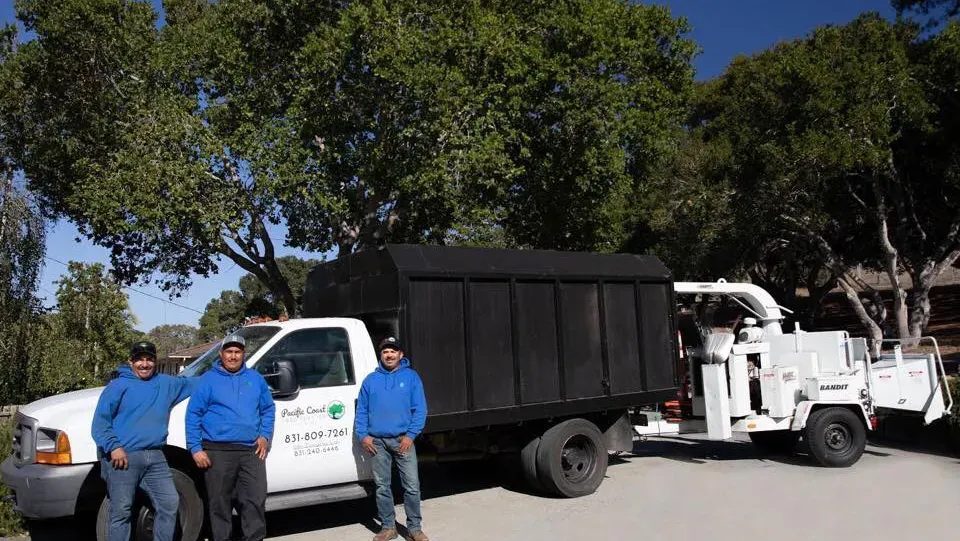 A group of men are standing in front of a truck.