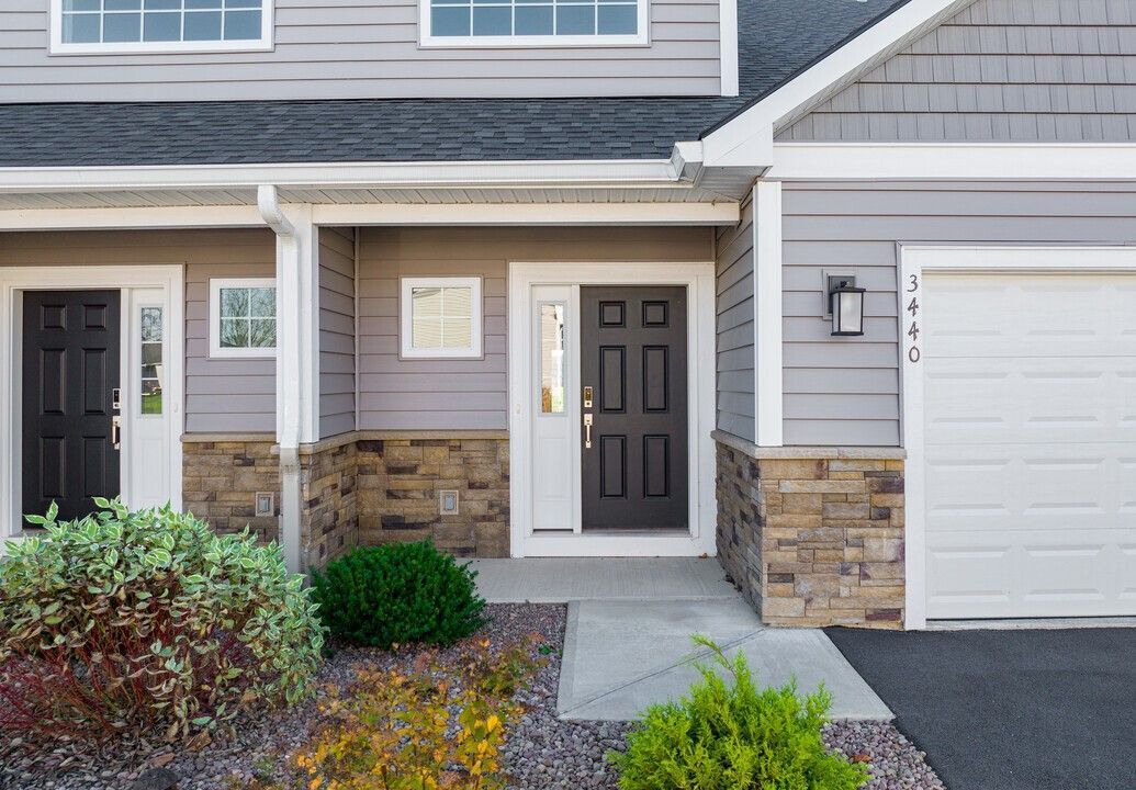 The front of a house with a black door and a white garage door.