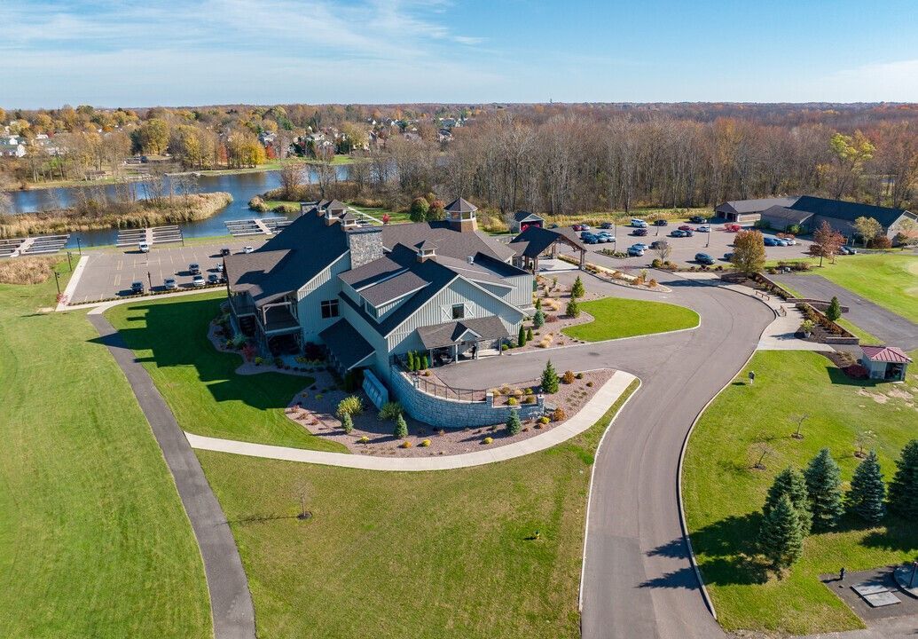An aerial view of a large house in a residential area with a lake in the background.