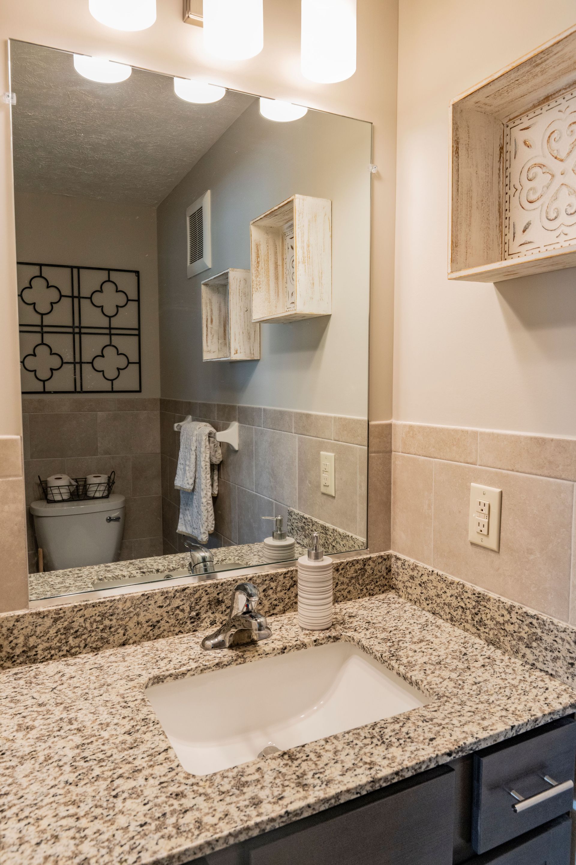 A bathroom with a sink , mirror and toilet.