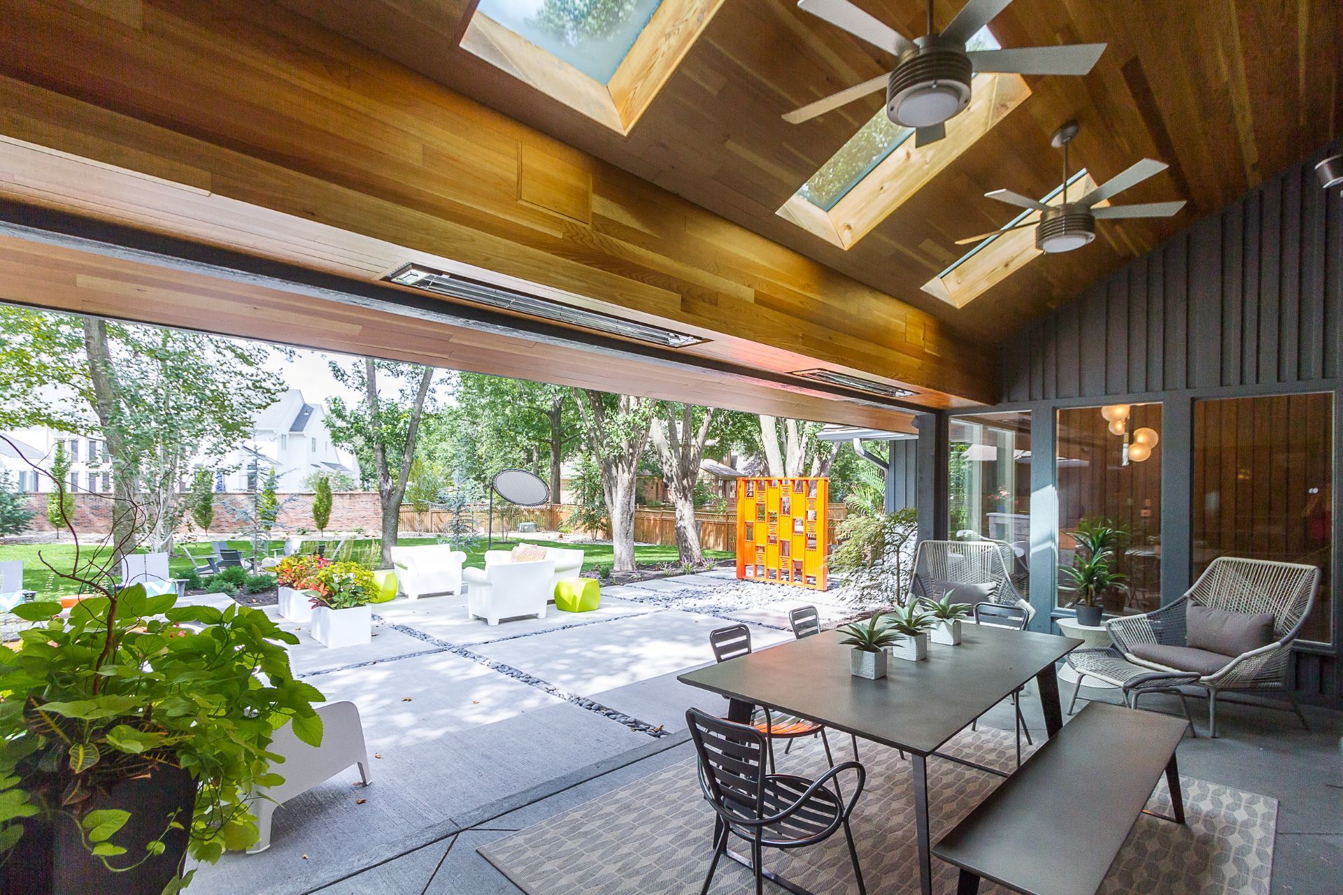 A patio with a table and chairs and a ceiling fan.