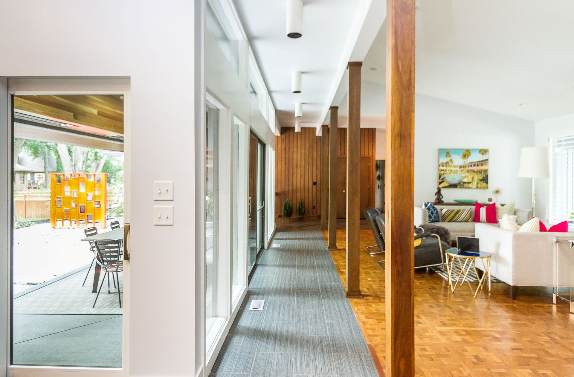 A long hallway in a house leading to a living room and dining room.