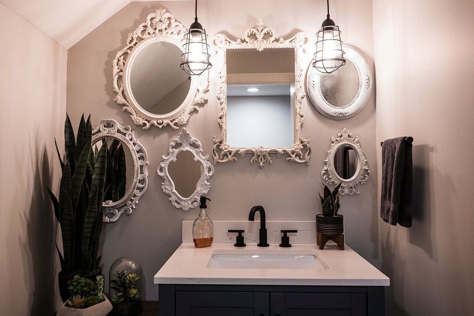 A bathroom with a sink and mirrors on the wall.