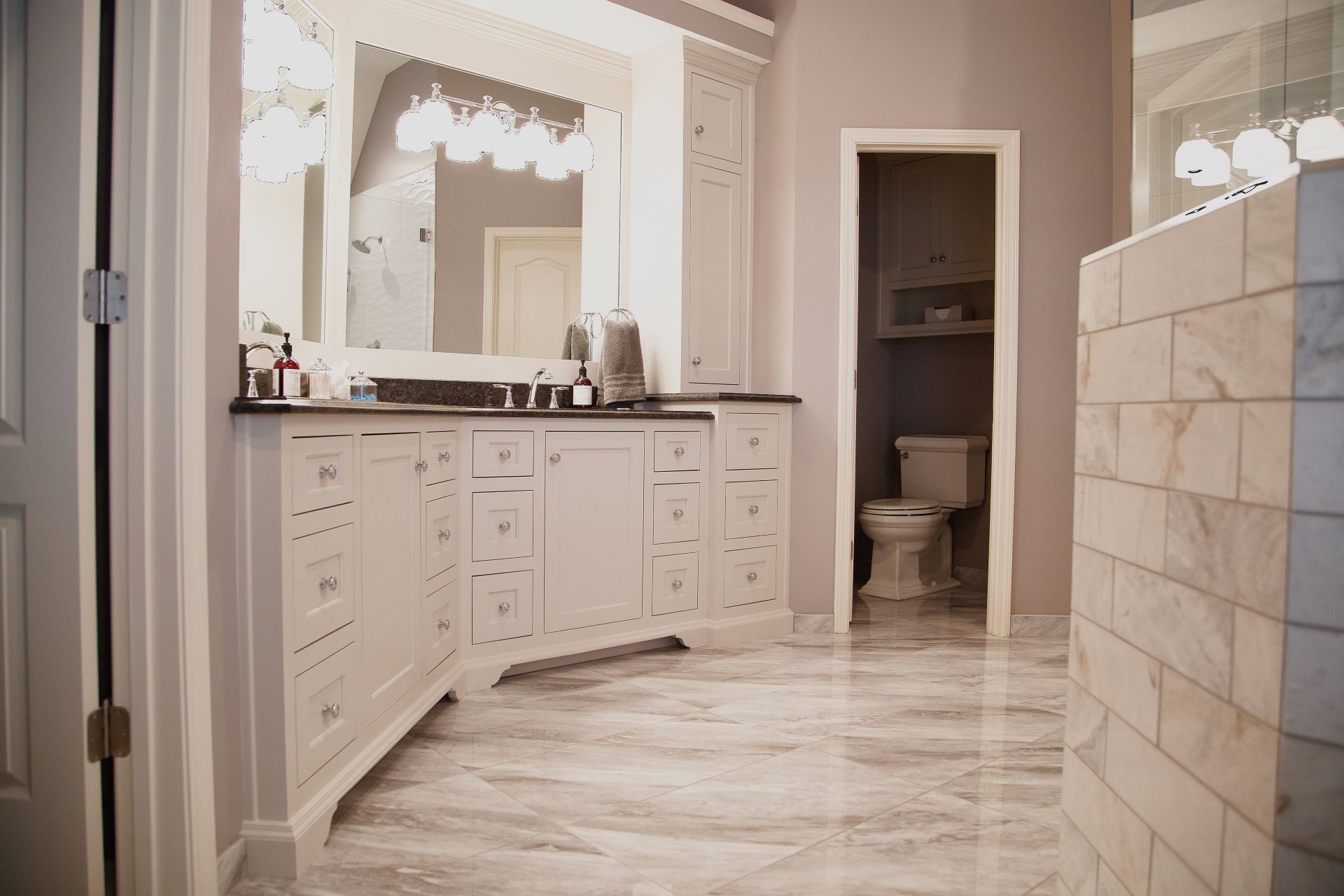 A bathroom with two sinks , a toilet , and a walk in shower.
