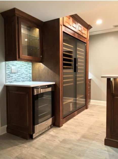 A kitchen with a refrigerator and a wine cooler