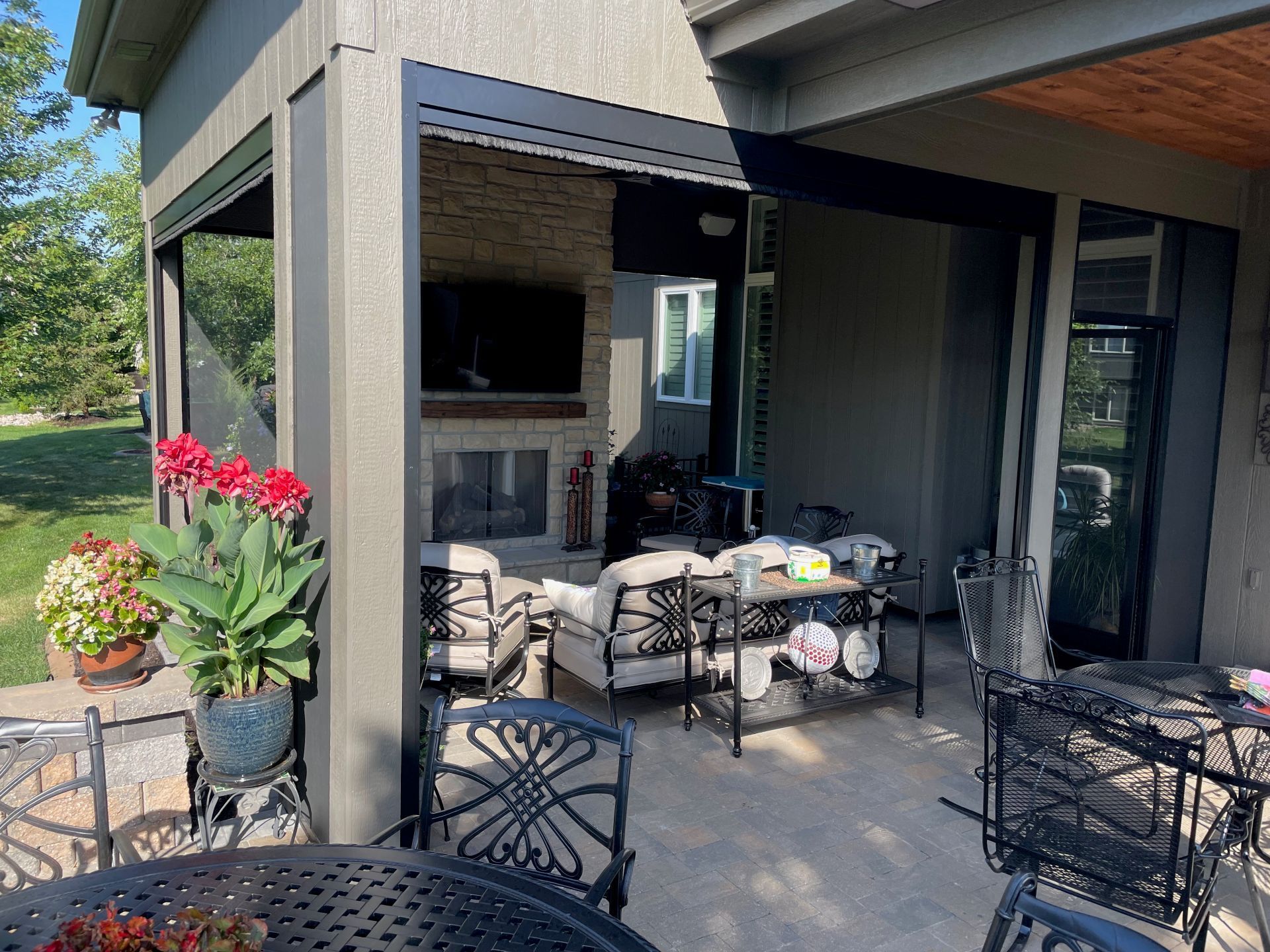 A patio with a table and chairs and a fireplace.