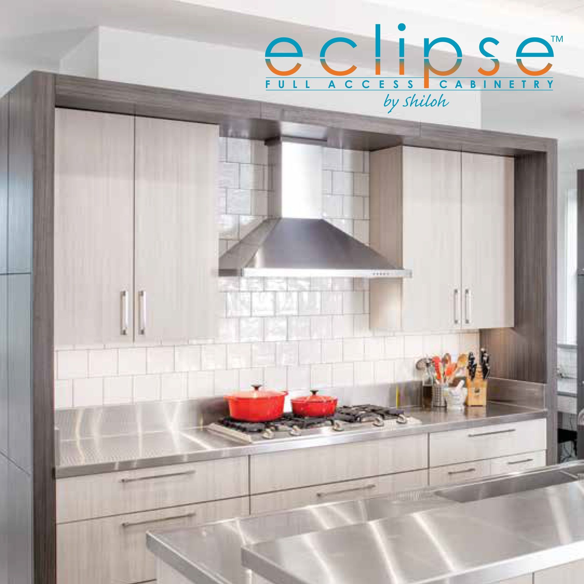 A kitchen with white cabinets and stainless steel counter tops