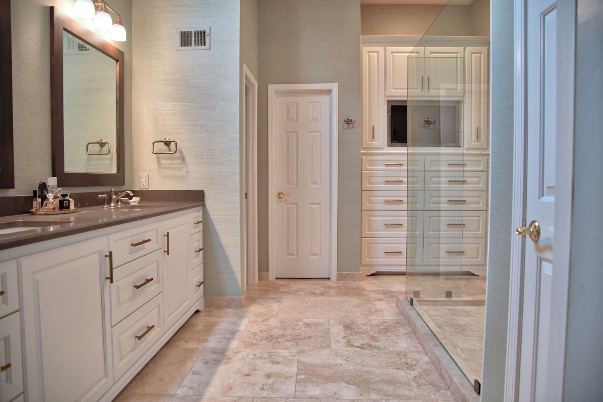 A bathroom with two sinks and a walk in shower.