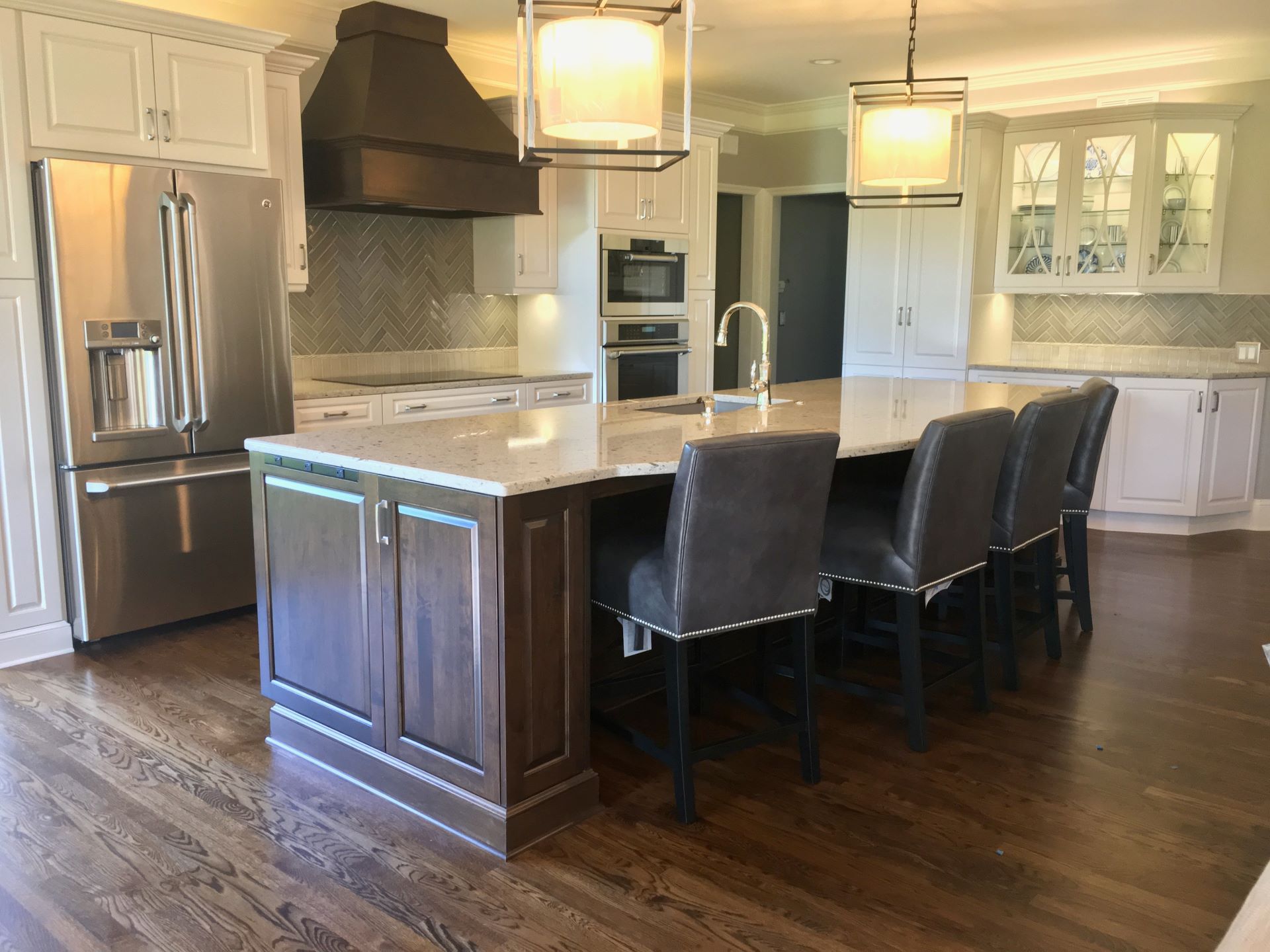 A kitchen with a large island and chairs in it