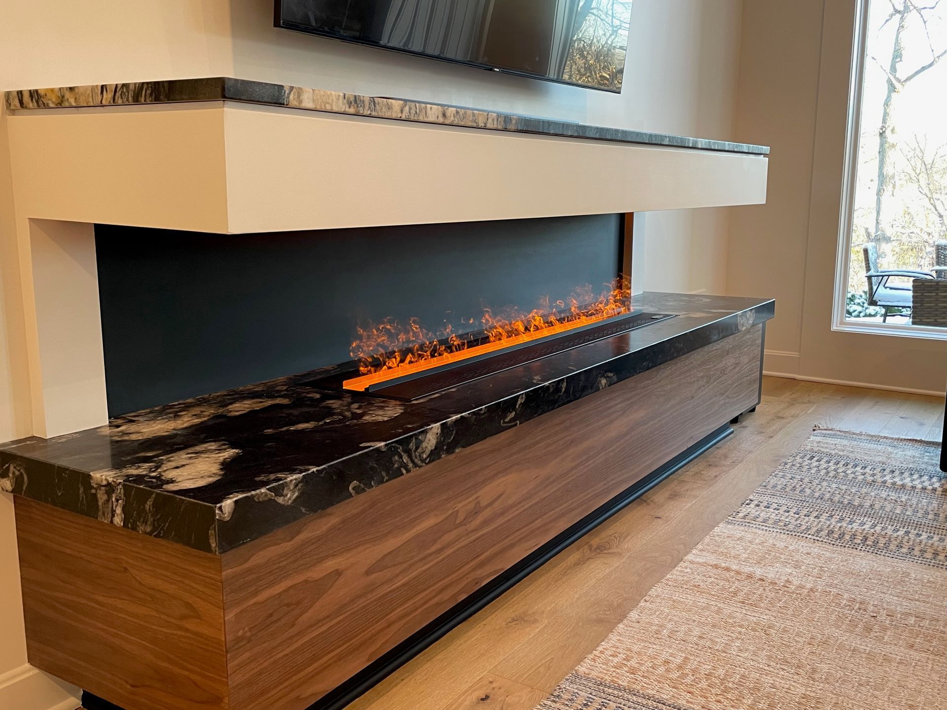 A living room with a fireplace and a flat screen tv.