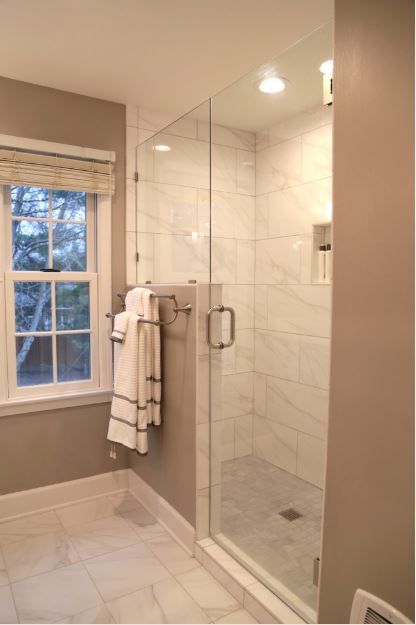 A bathroom with a walk in shower and a window