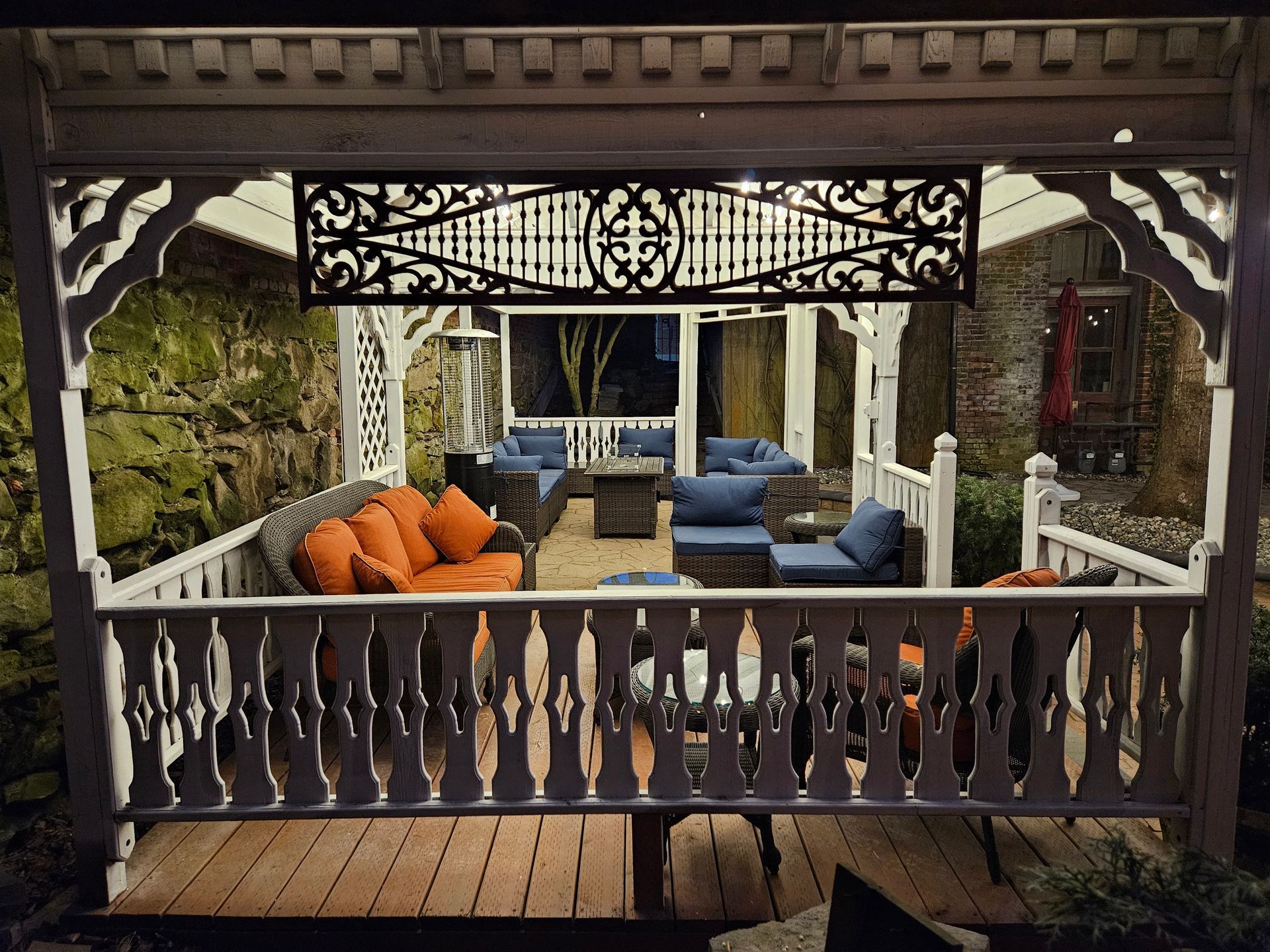 A gazebo with a couch and chairs inside of it