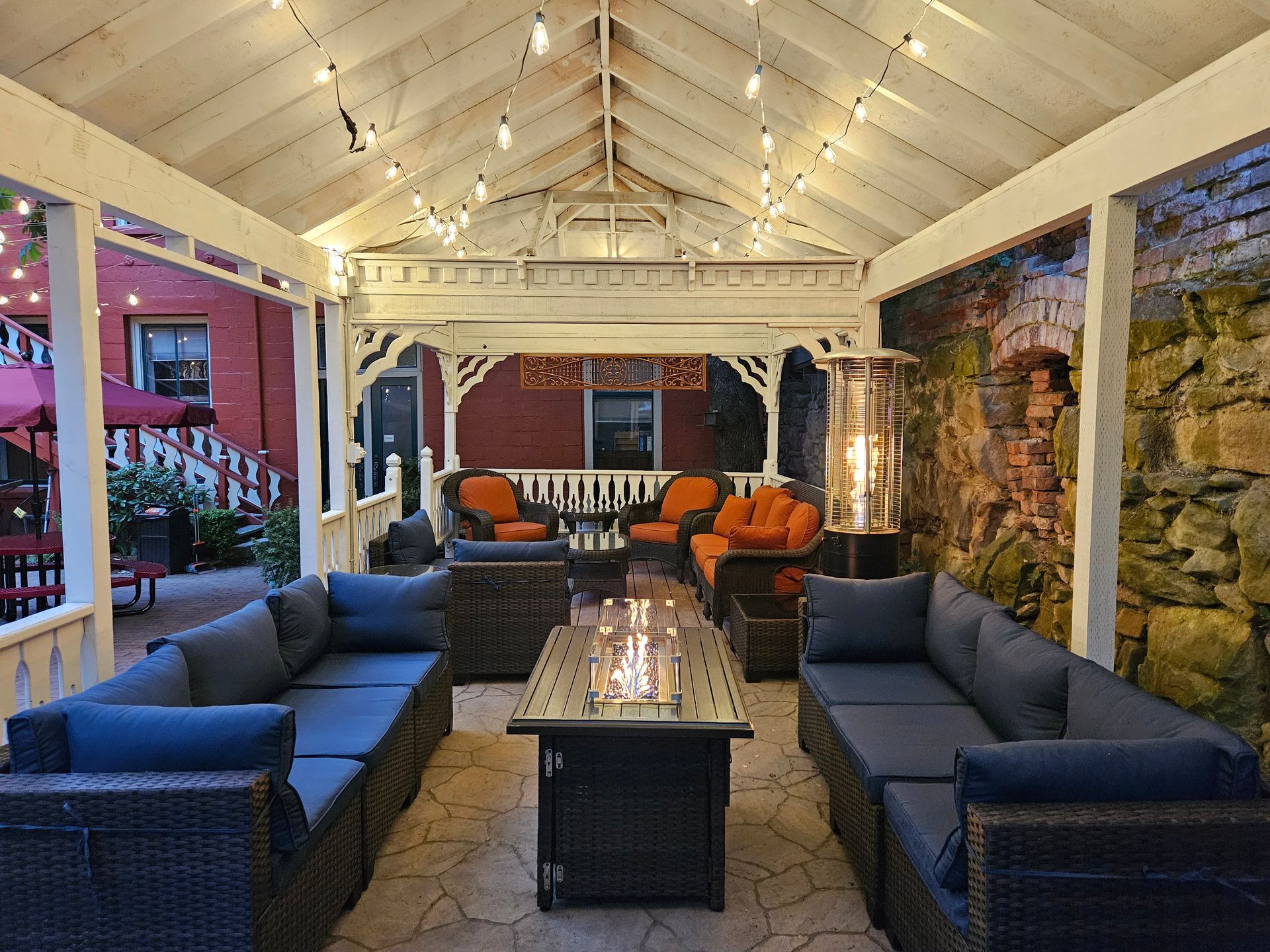 A patio with lots of furniture and a fire pit.