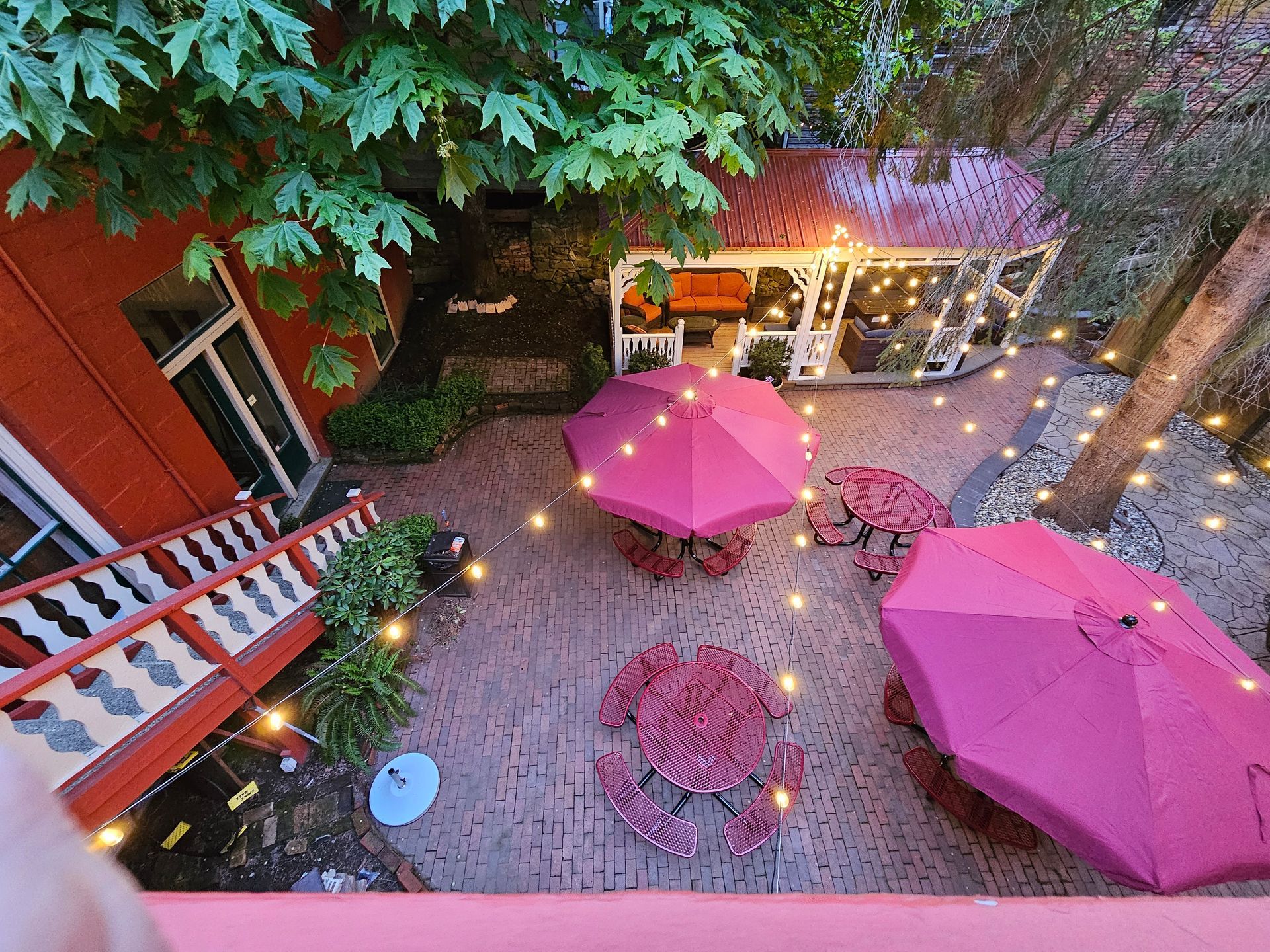 An aerial view of a patio with pink umbrellas and tables.