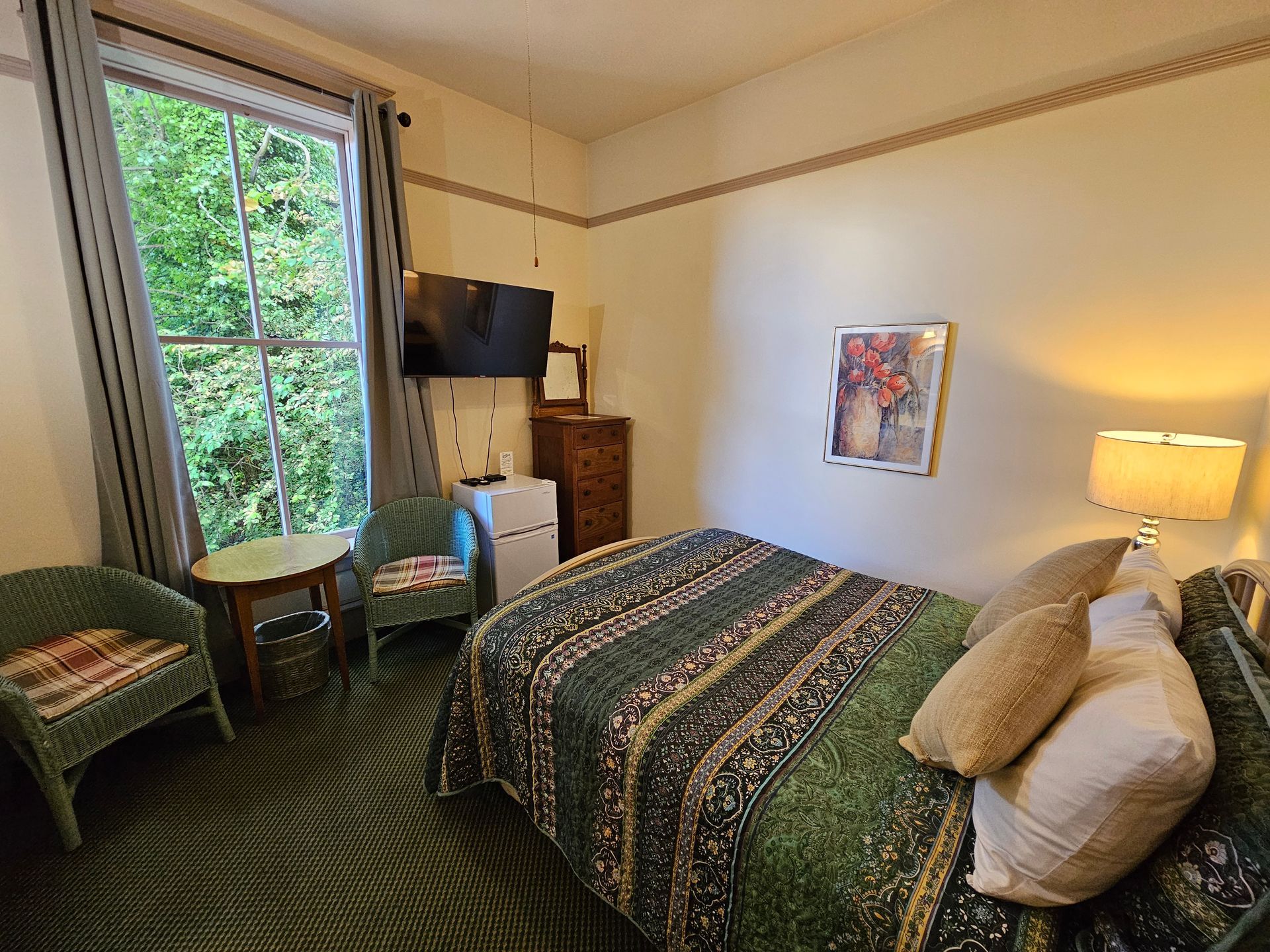 A bedroom with a bed , chair , table and television.