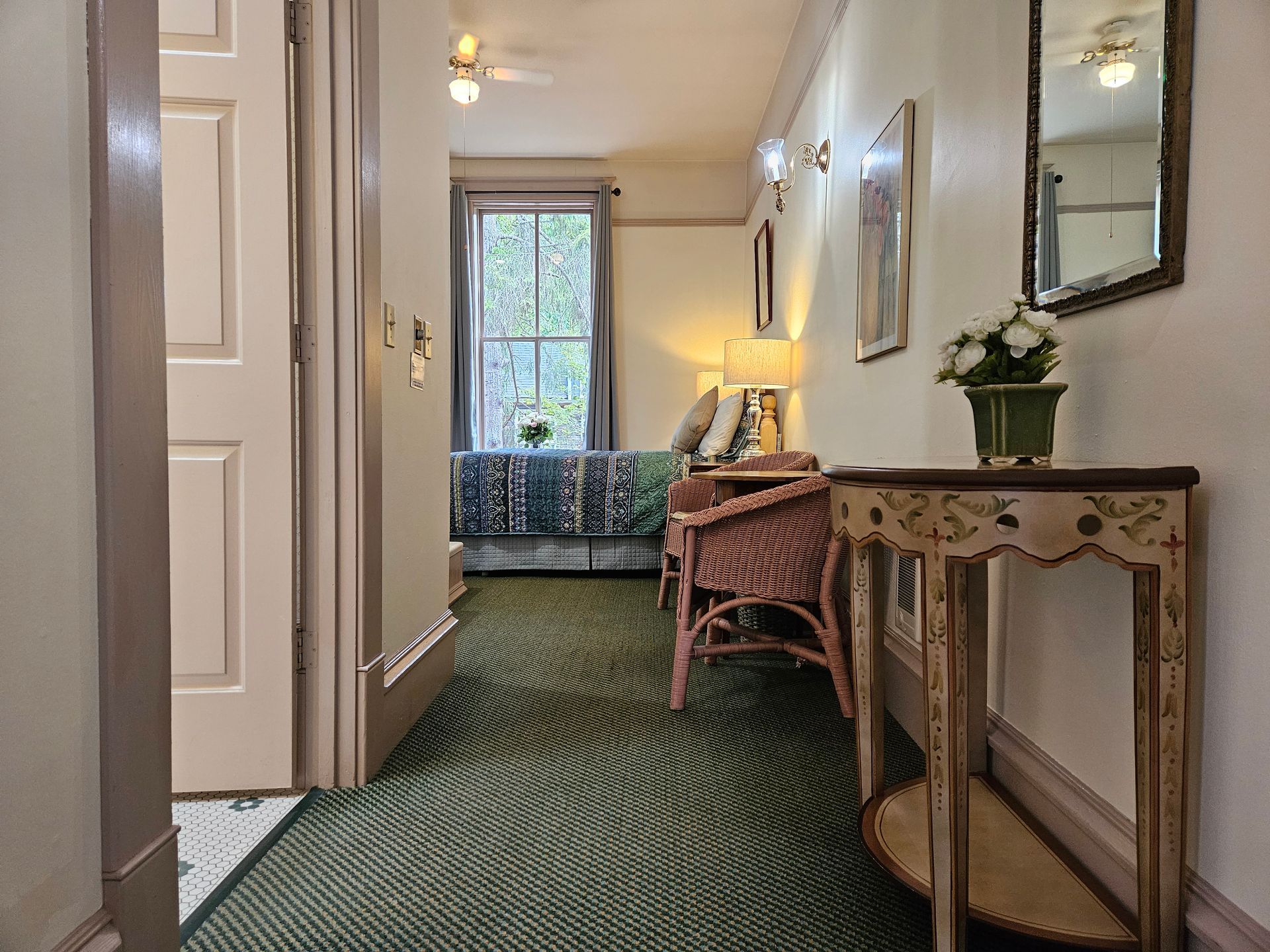 A hallway leading to a living room with a table and chairs