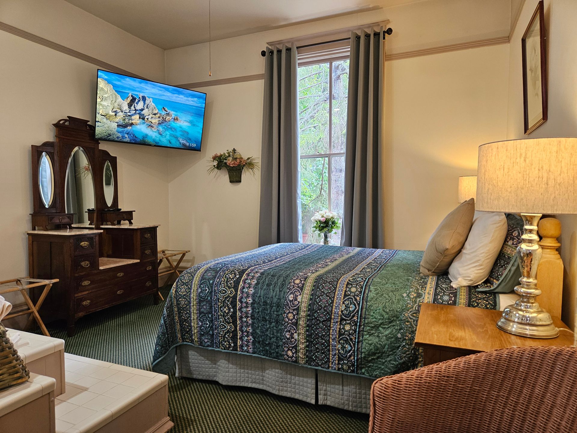 A bedroom with a bed , dresser , lamp and television.