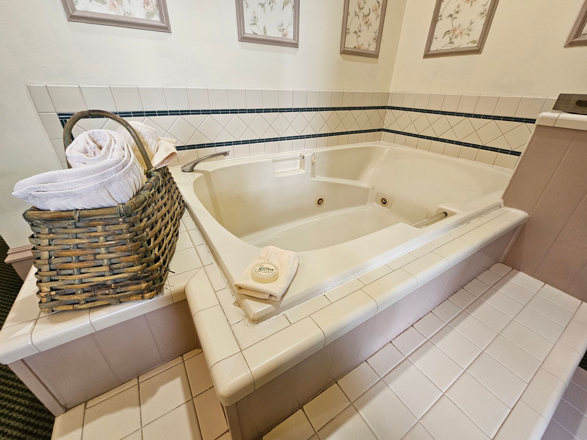 A bathroom with a jacuzzi tub and a basket of towels