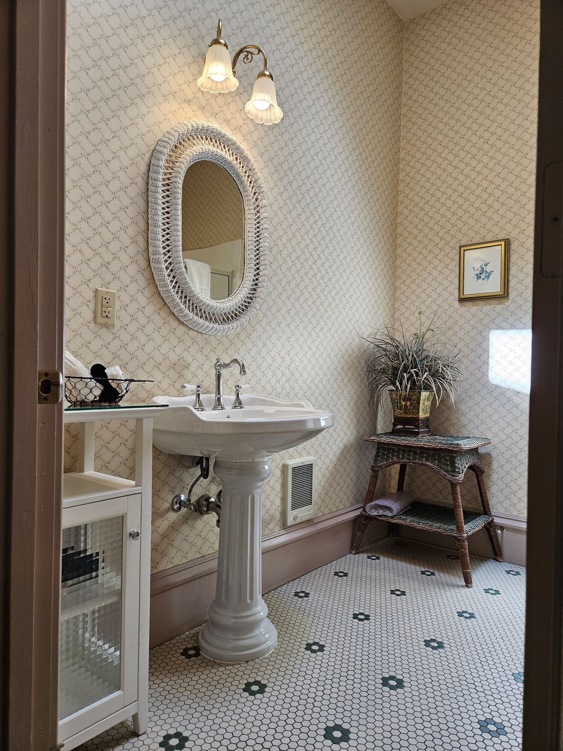 A bathroom with a pedestal sink and a mirror