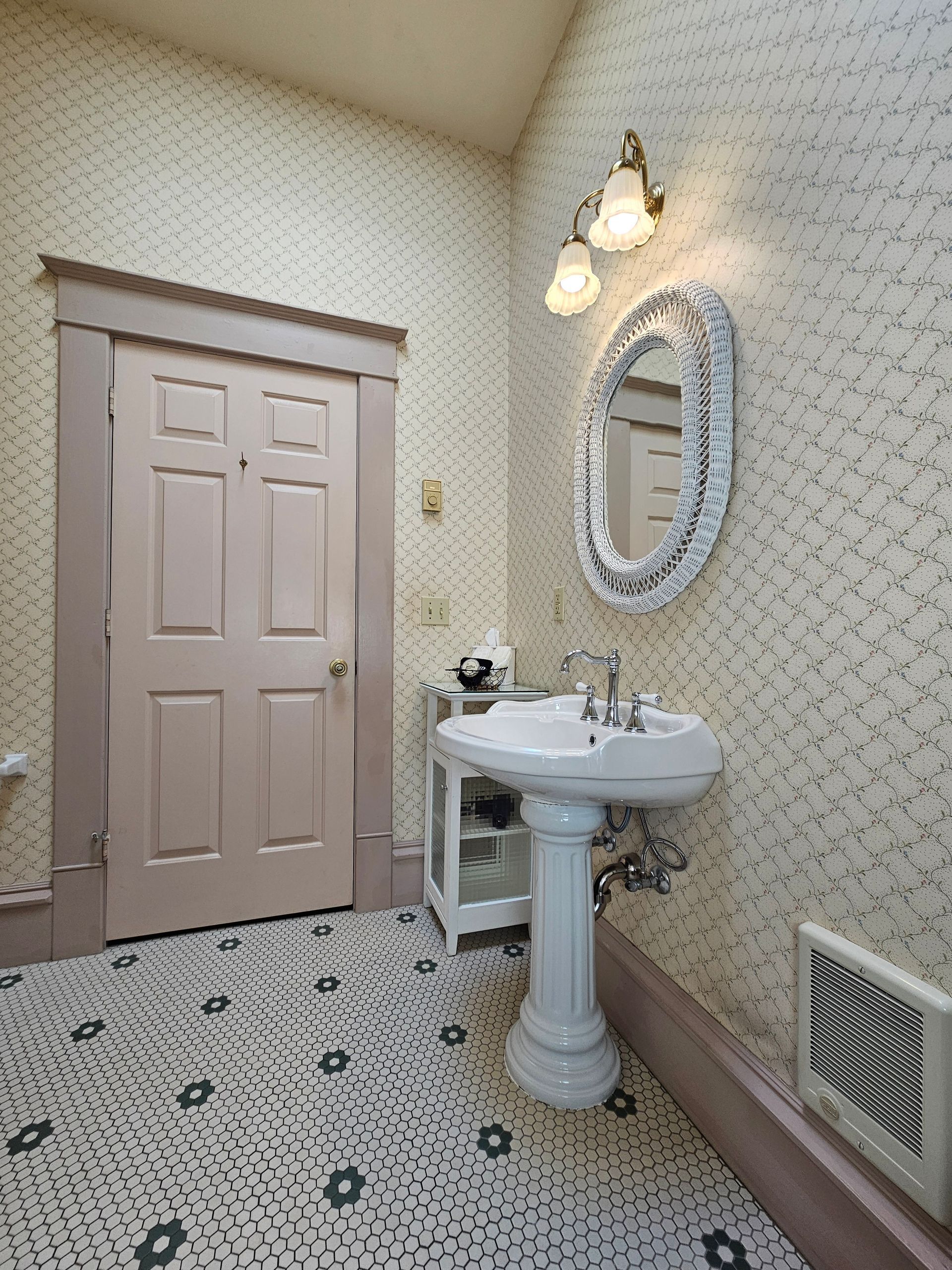 A bathroom with a pedestal sink and a mirror