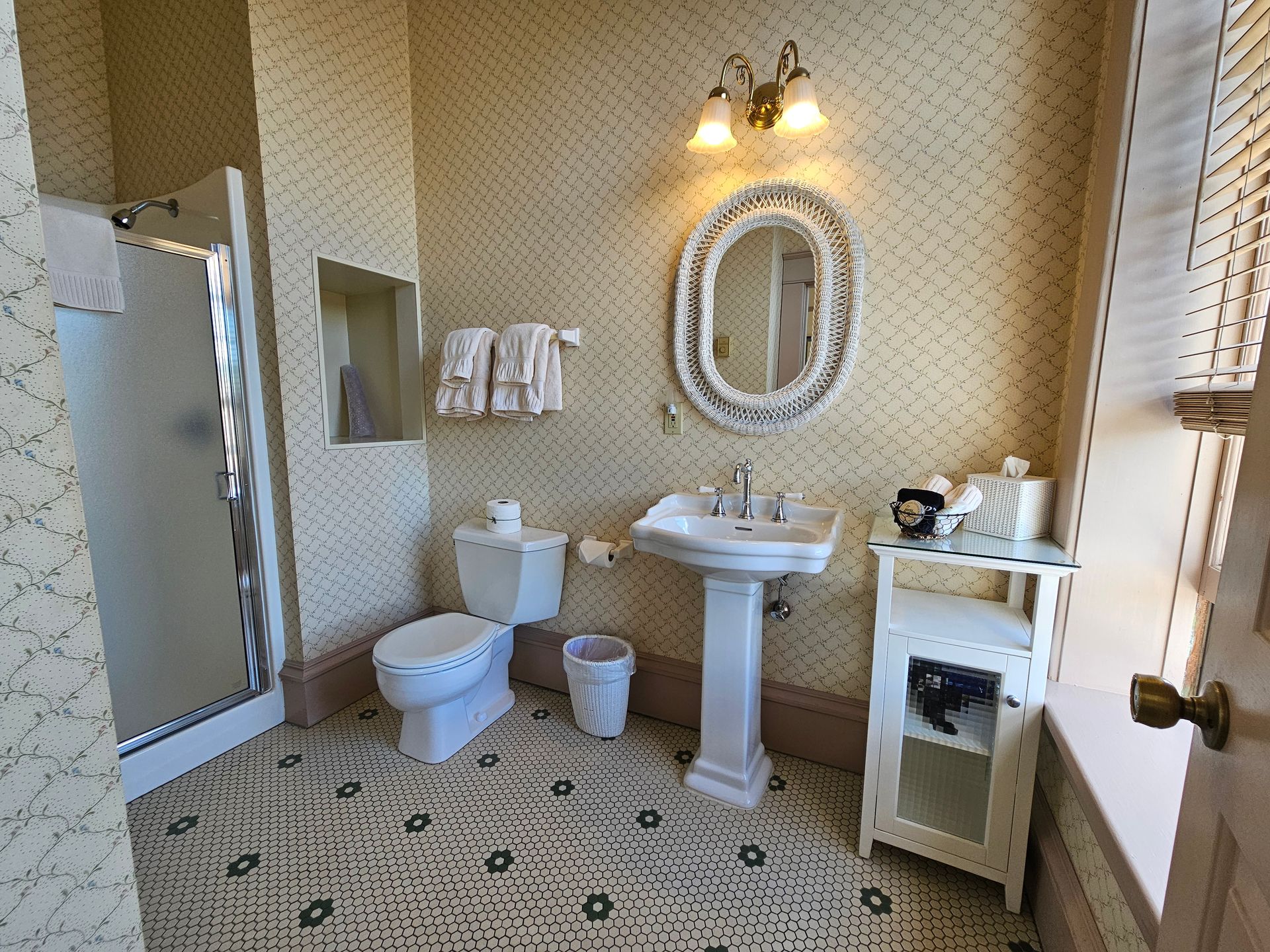 A bathroom with a toilet , sink , mirror and shower.