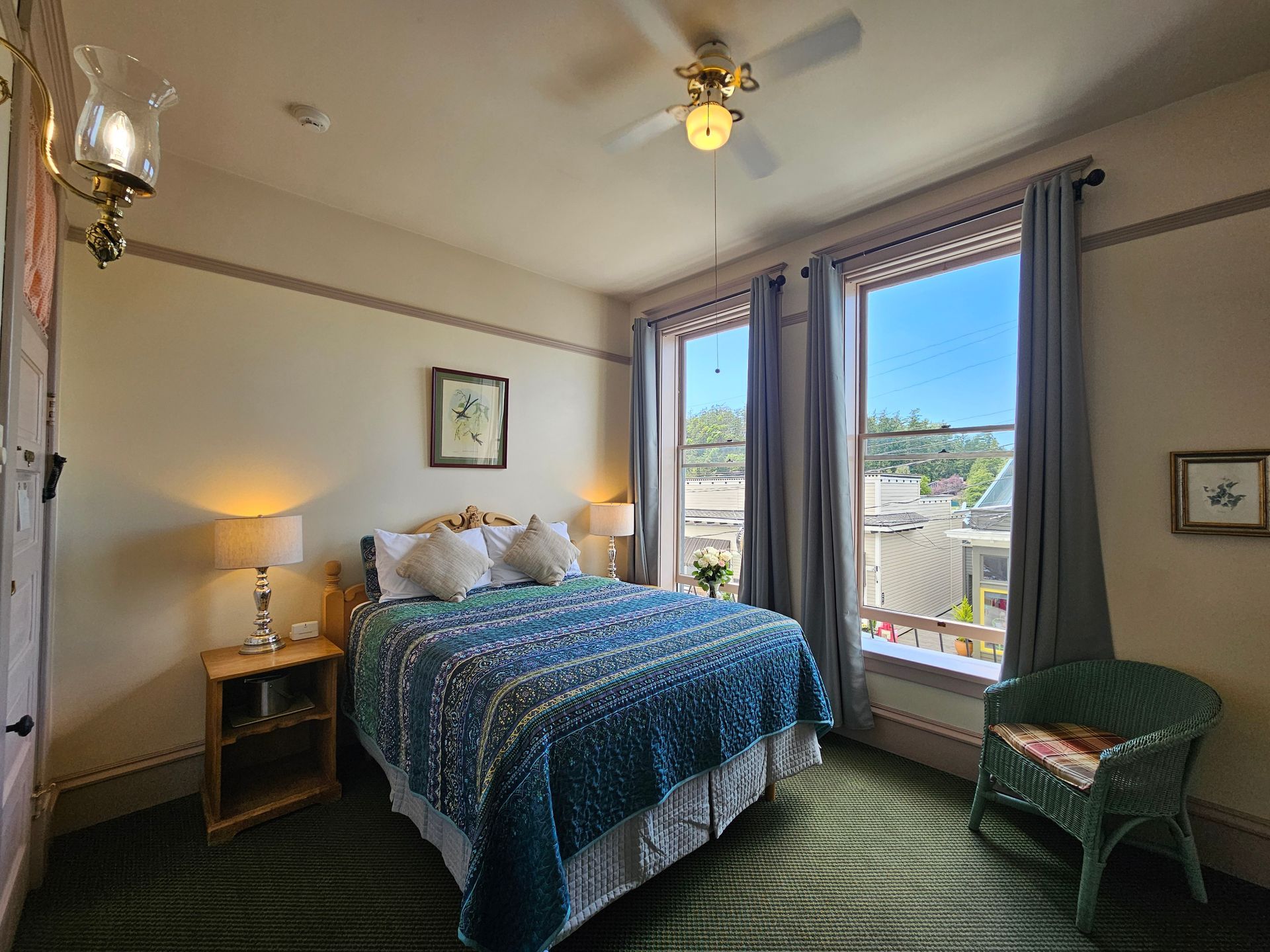 A bedroom with a bed and a ceiling fan