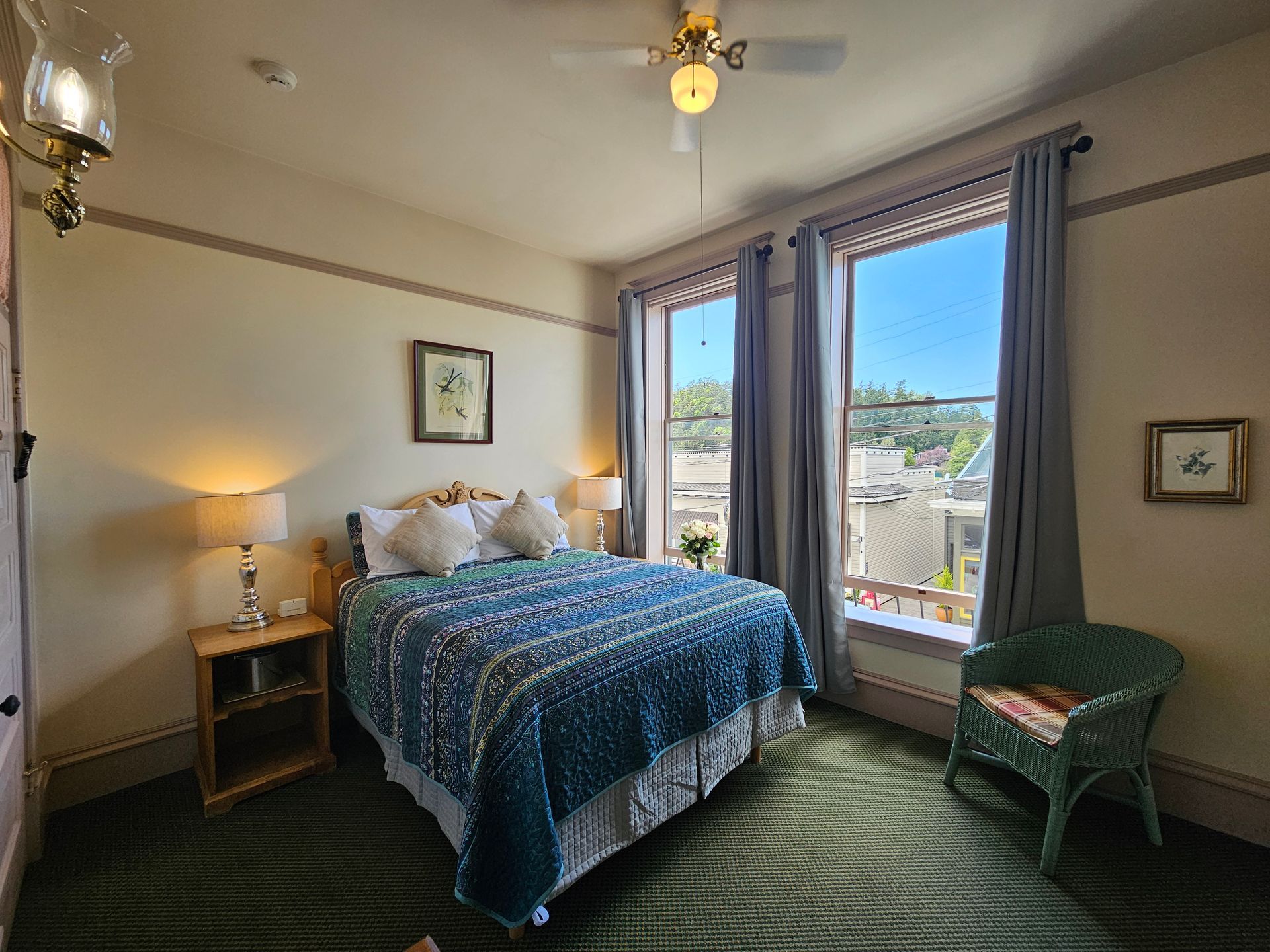 A bedroom with a large bed and a ceiling fan