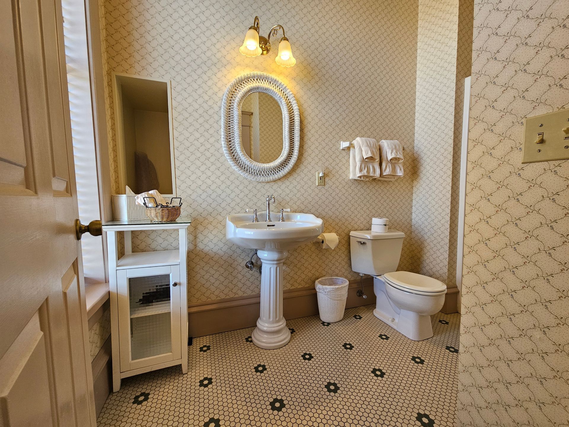 A bathroom with a sink , toilet , mirror and towels.