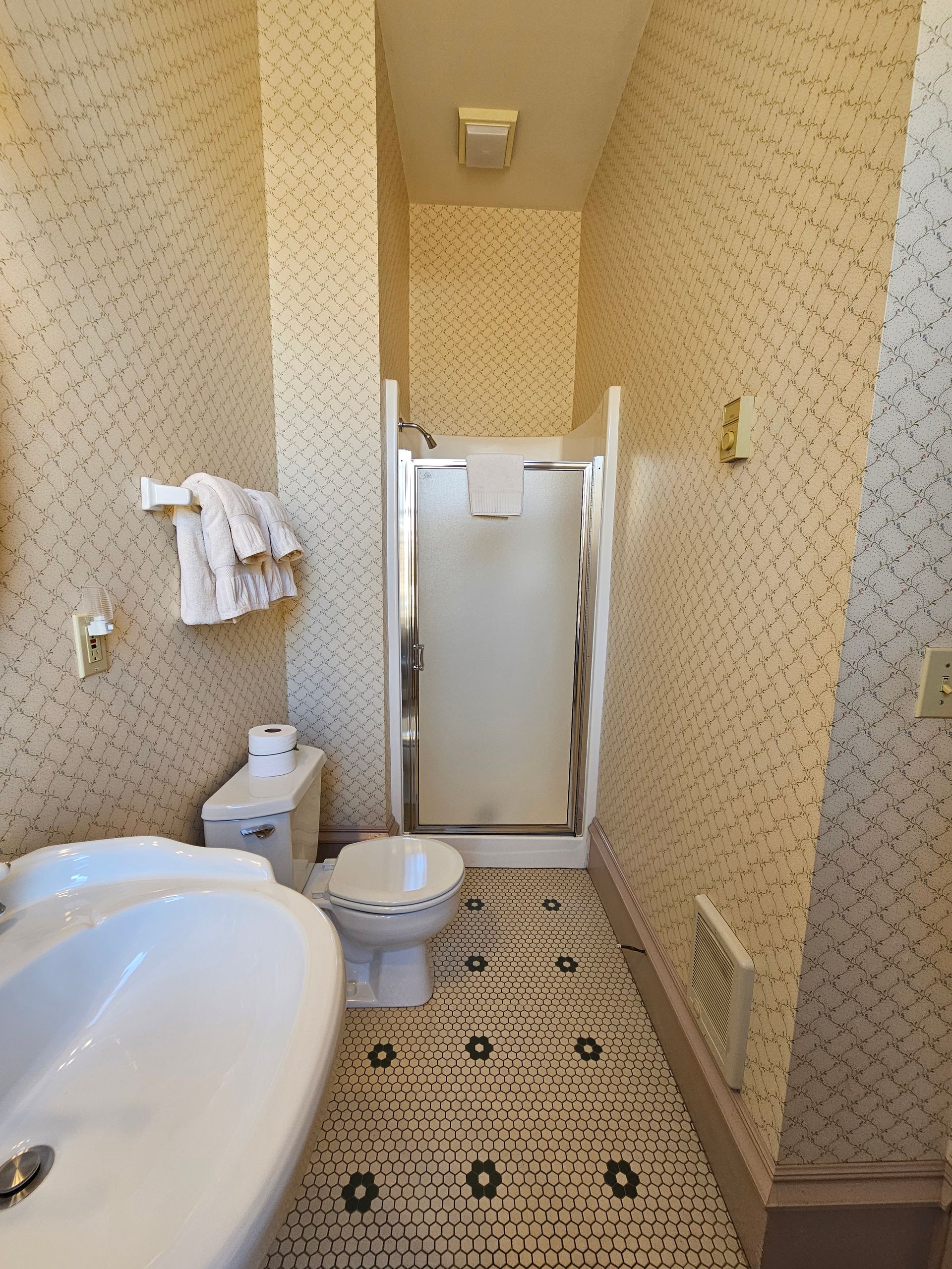 A bathroom with a toilet , sink , and shower.