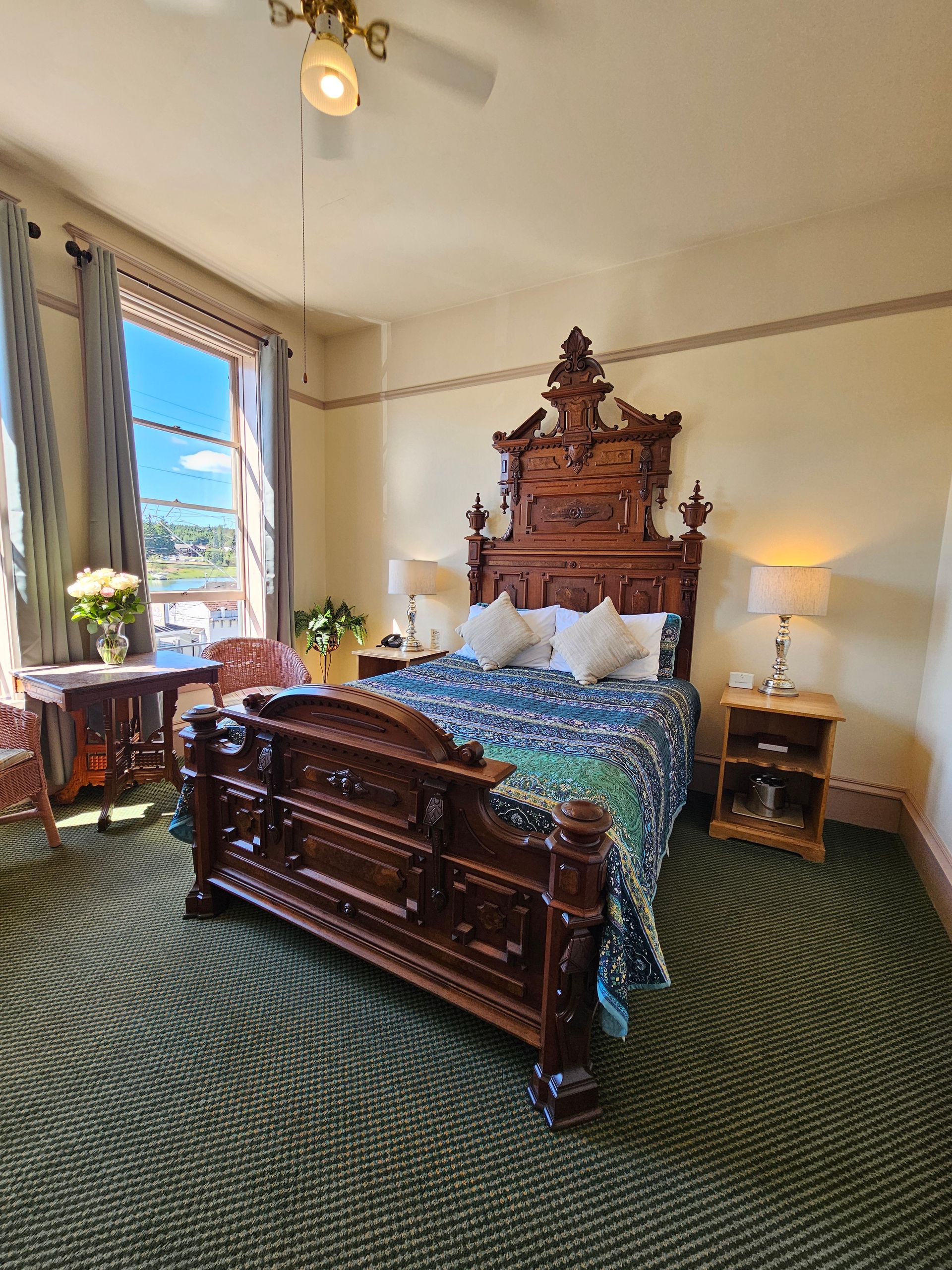 A bedroom with a large bed and a ceiling fan.