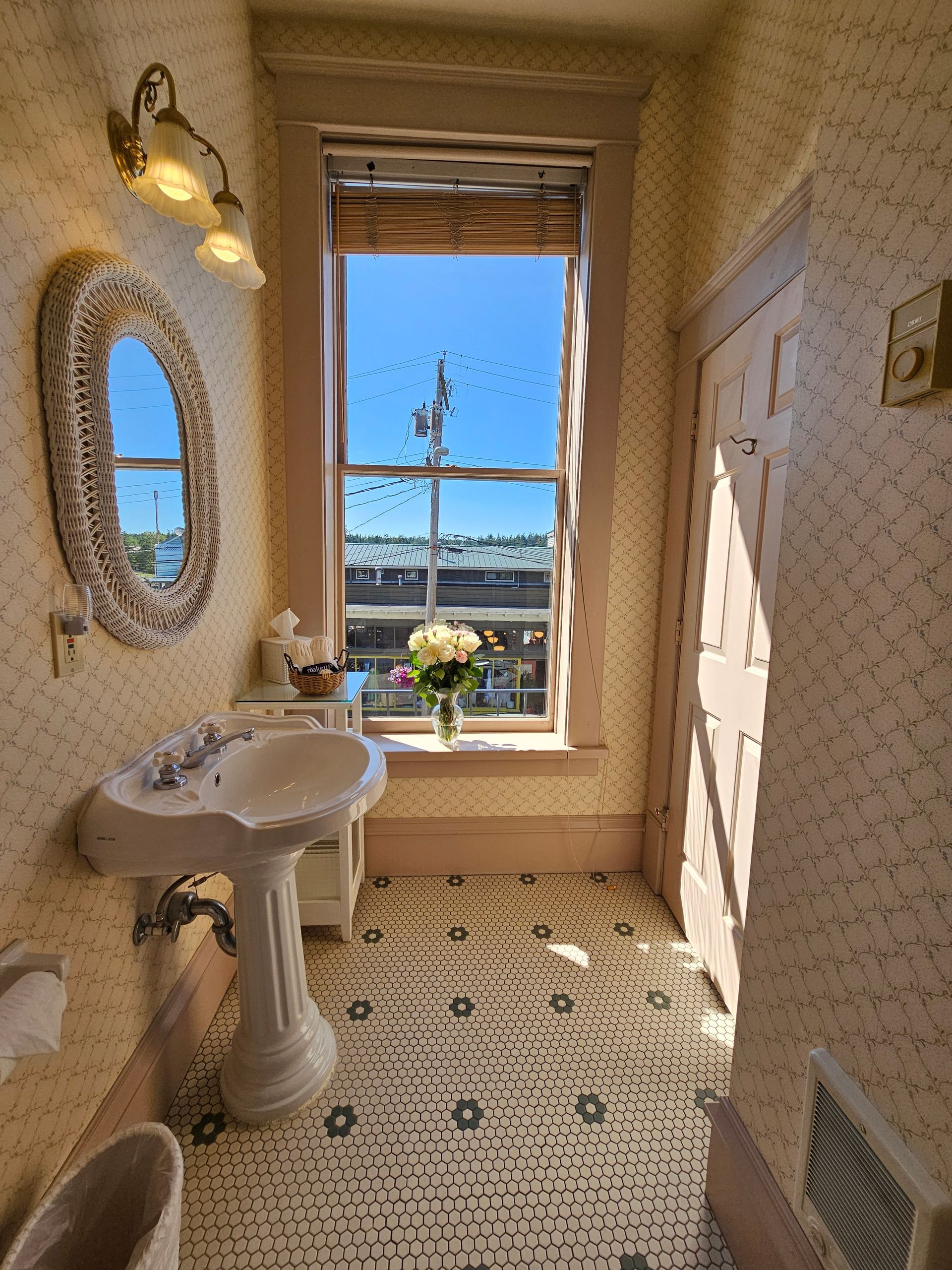 A bathroom with a sink , mirror , and window.