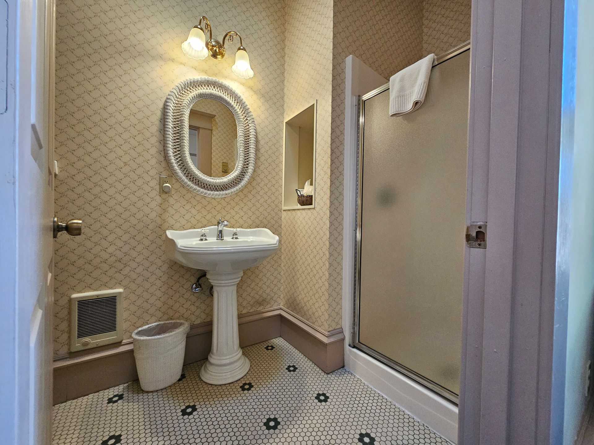 A bathroom with a sink , mirror and shower.