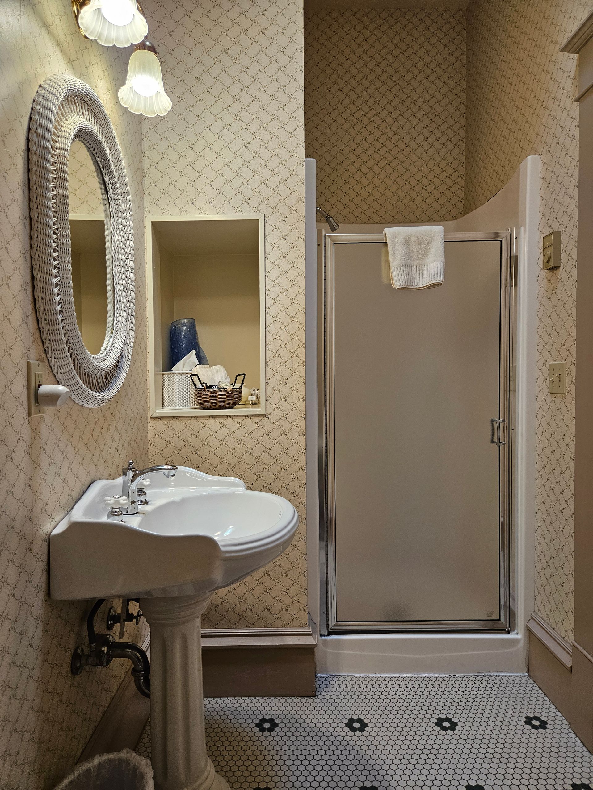 A bathroom with a sink a mirror and a shower