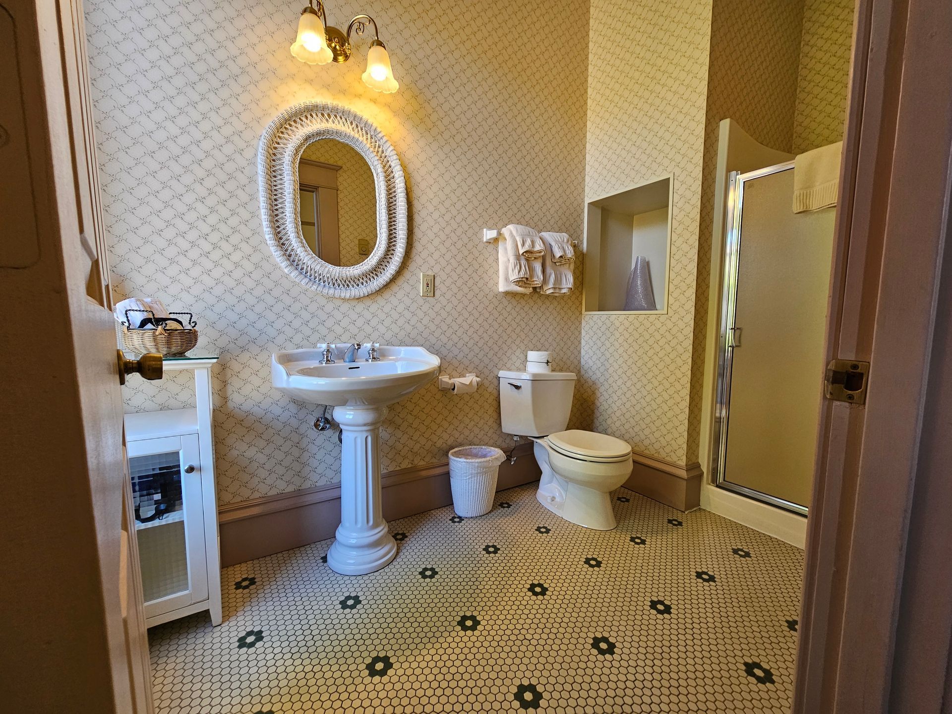 A bathroom with a sink , toilet , mirror and shower.