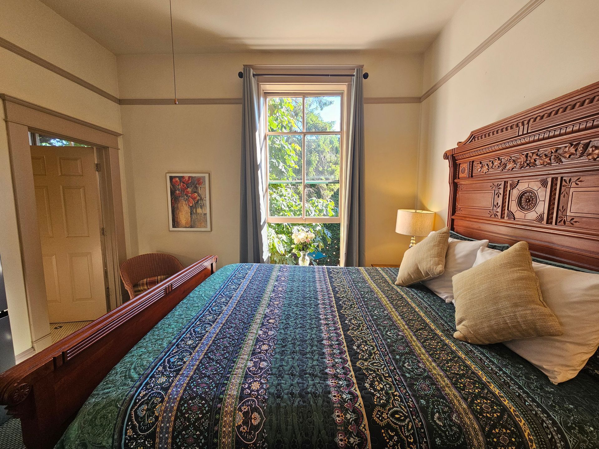 A bedroom with a king size bed and a window.