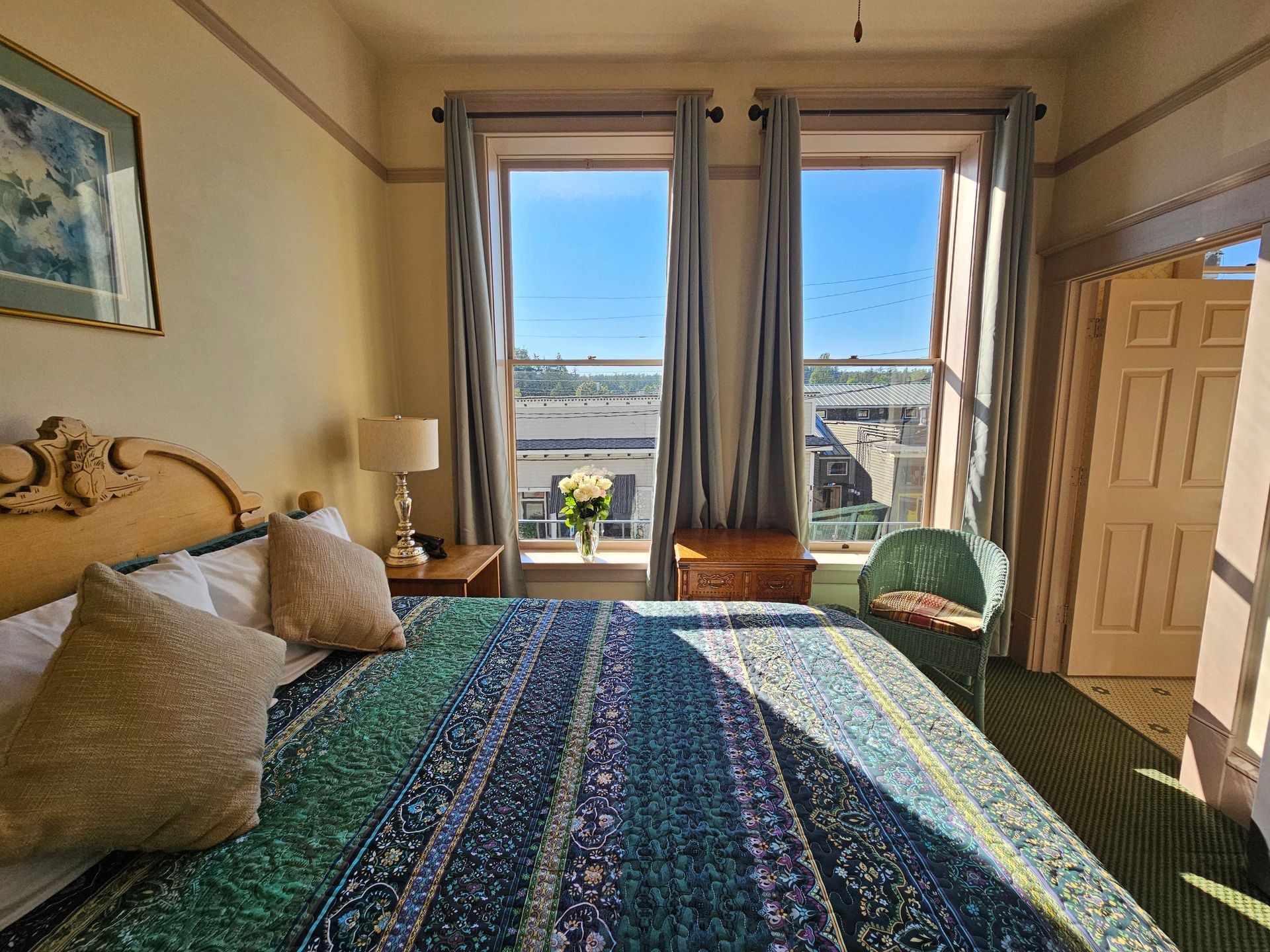 A bedroom with a king size bed and two windows.