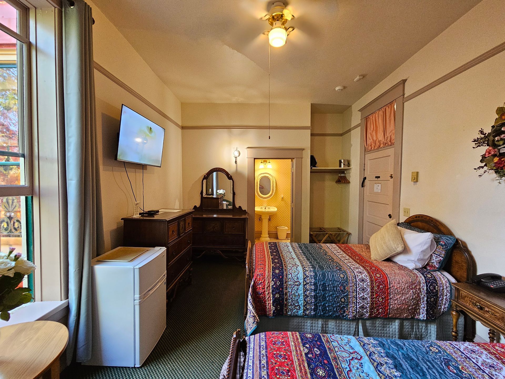 A hotel room with two beds and a flat screen tv.