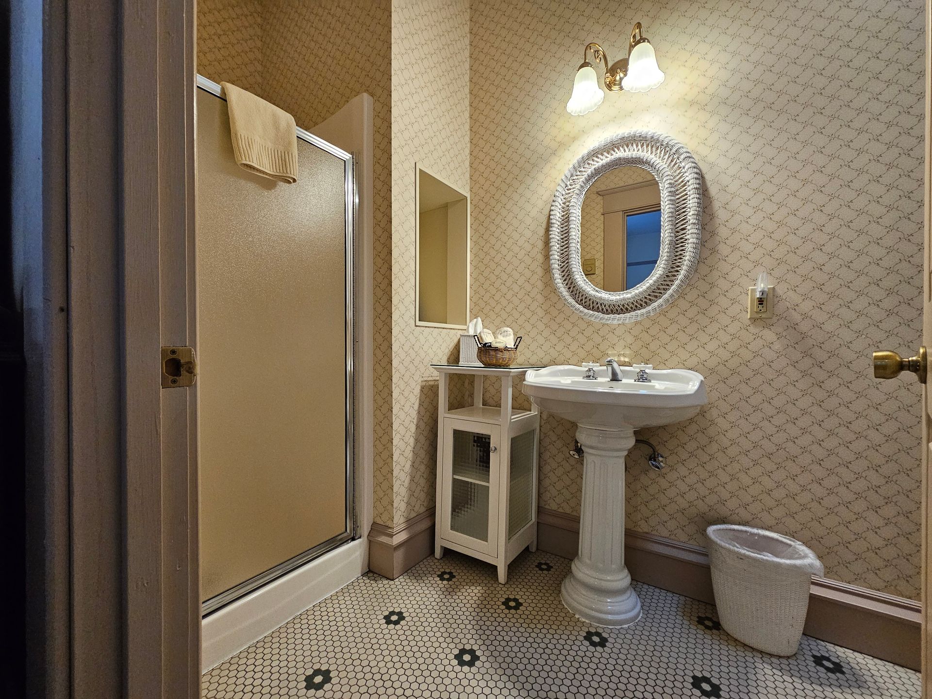 A bathroom with a sink , mirror and shower.