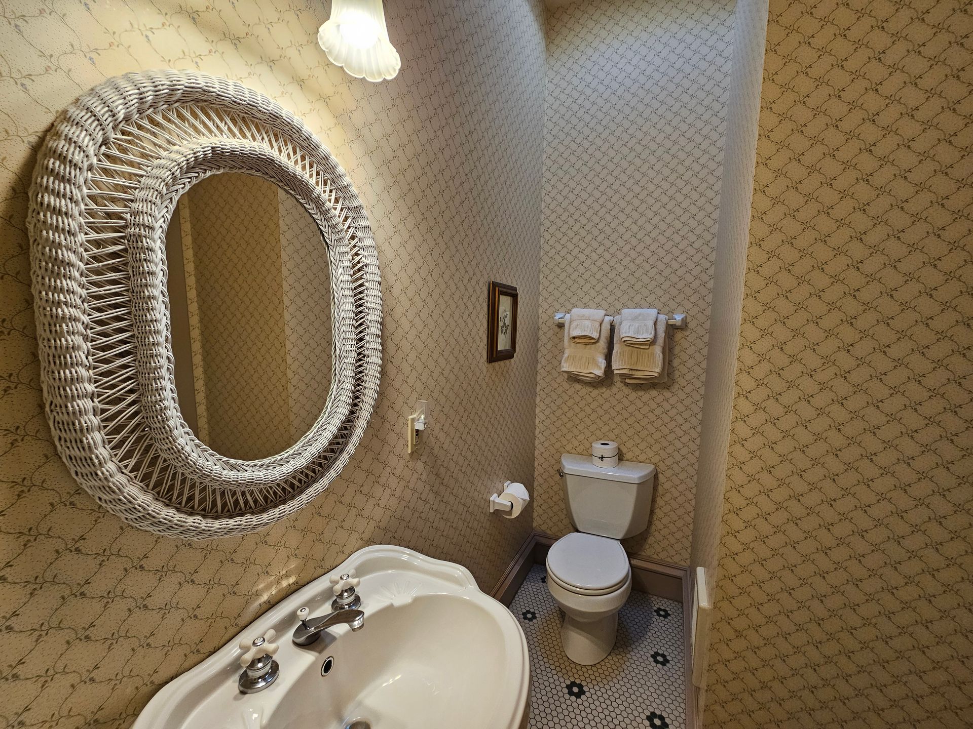 A bathroom with a toilet , sink and mirror