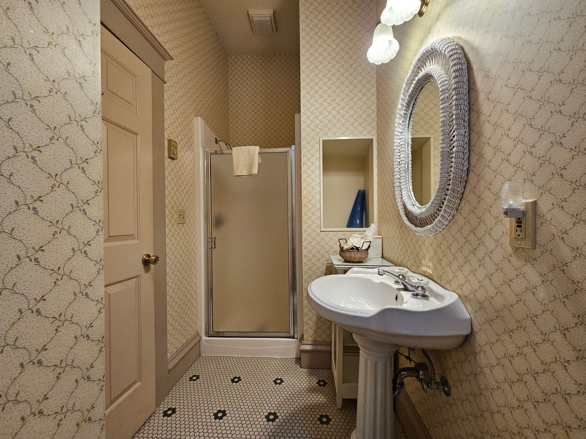 A bathroom with a sink a mirror and a walk in shower