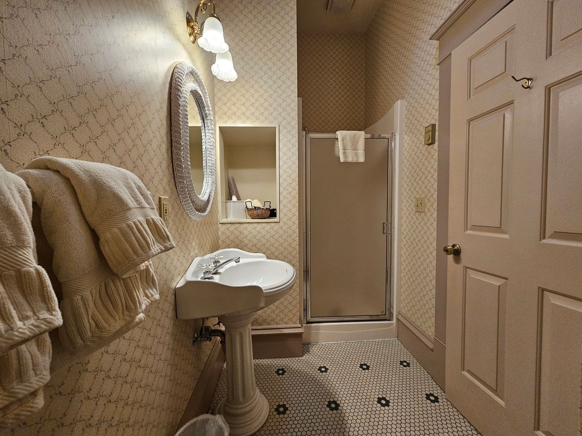 A bathroom with a sink , mirror and shower.