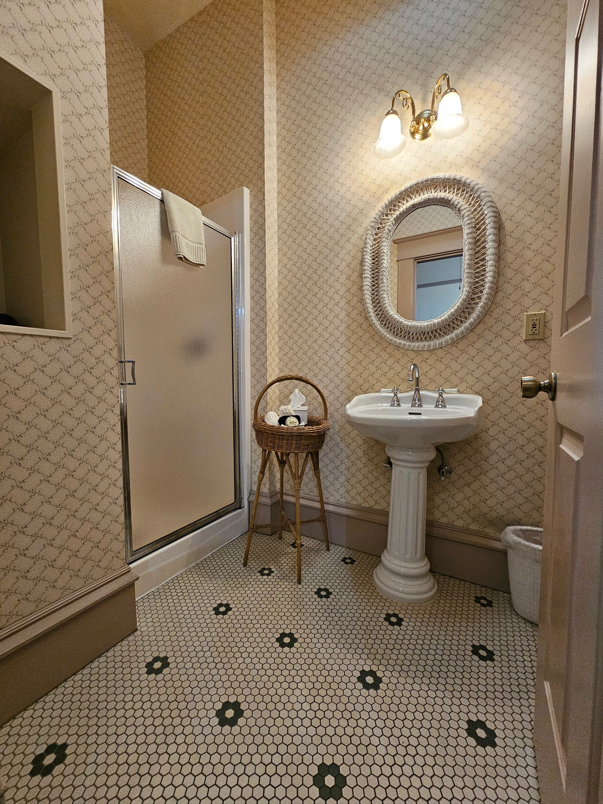 A bathroom with a sink , mirror and shower.