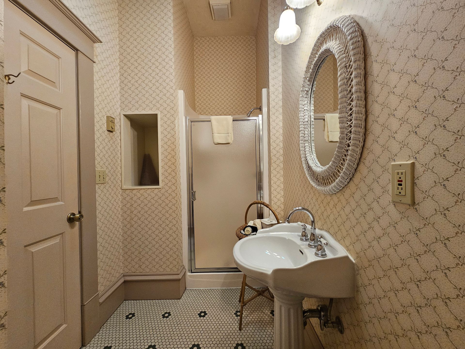 A bathroom with a sink a mirror and a walk in shower