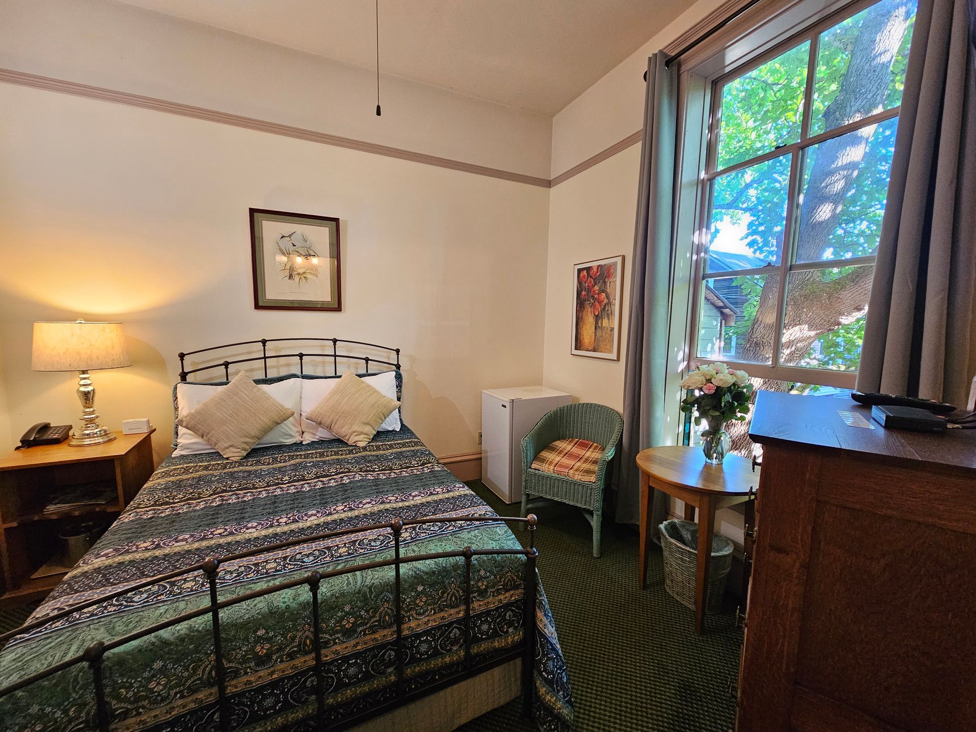 A bedroom with a bed , chair , table and window